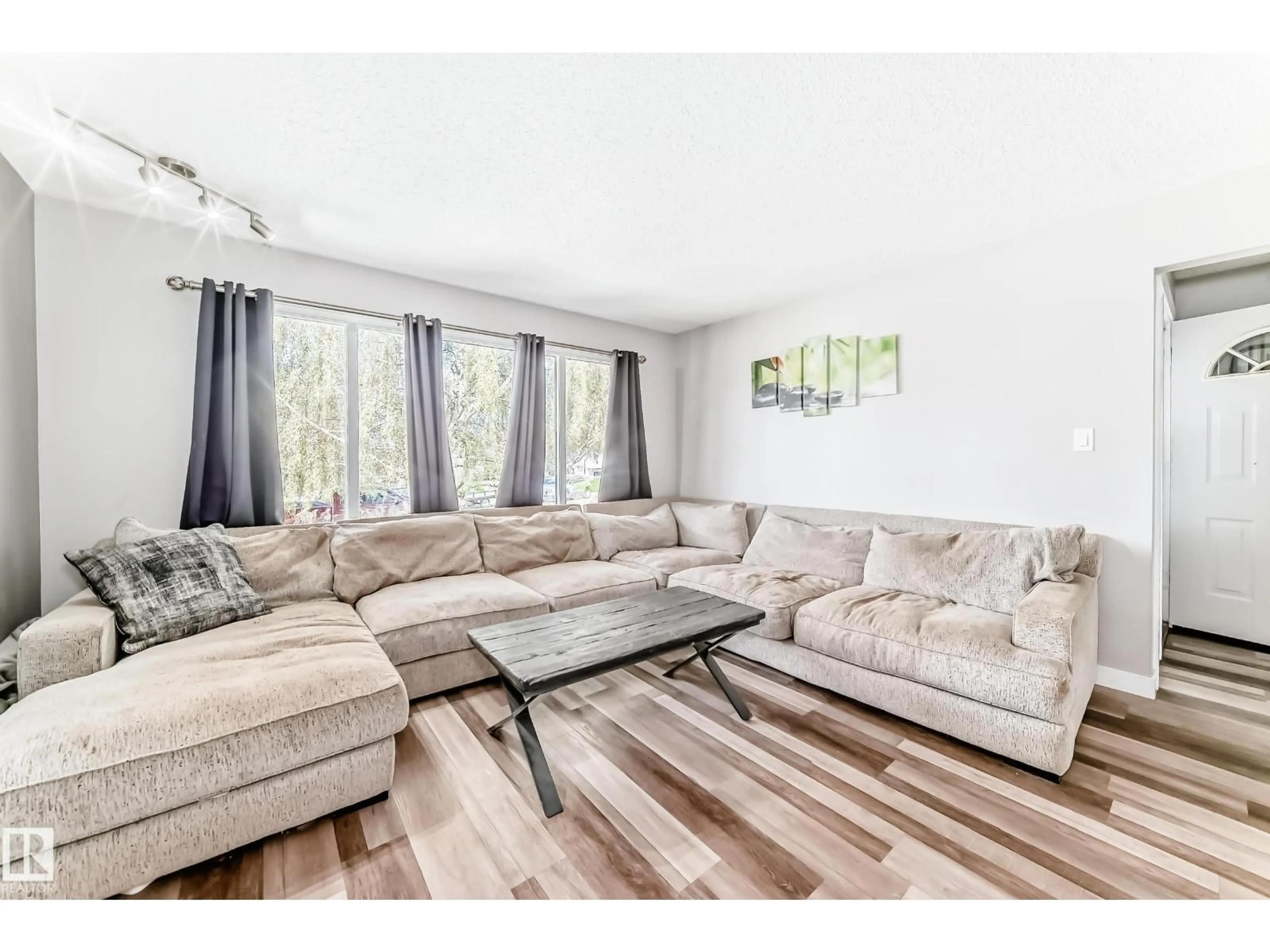 Living room with furniture, wood/laminate floor for 8803 16 AV, Edmonton Alberta T6K2A4