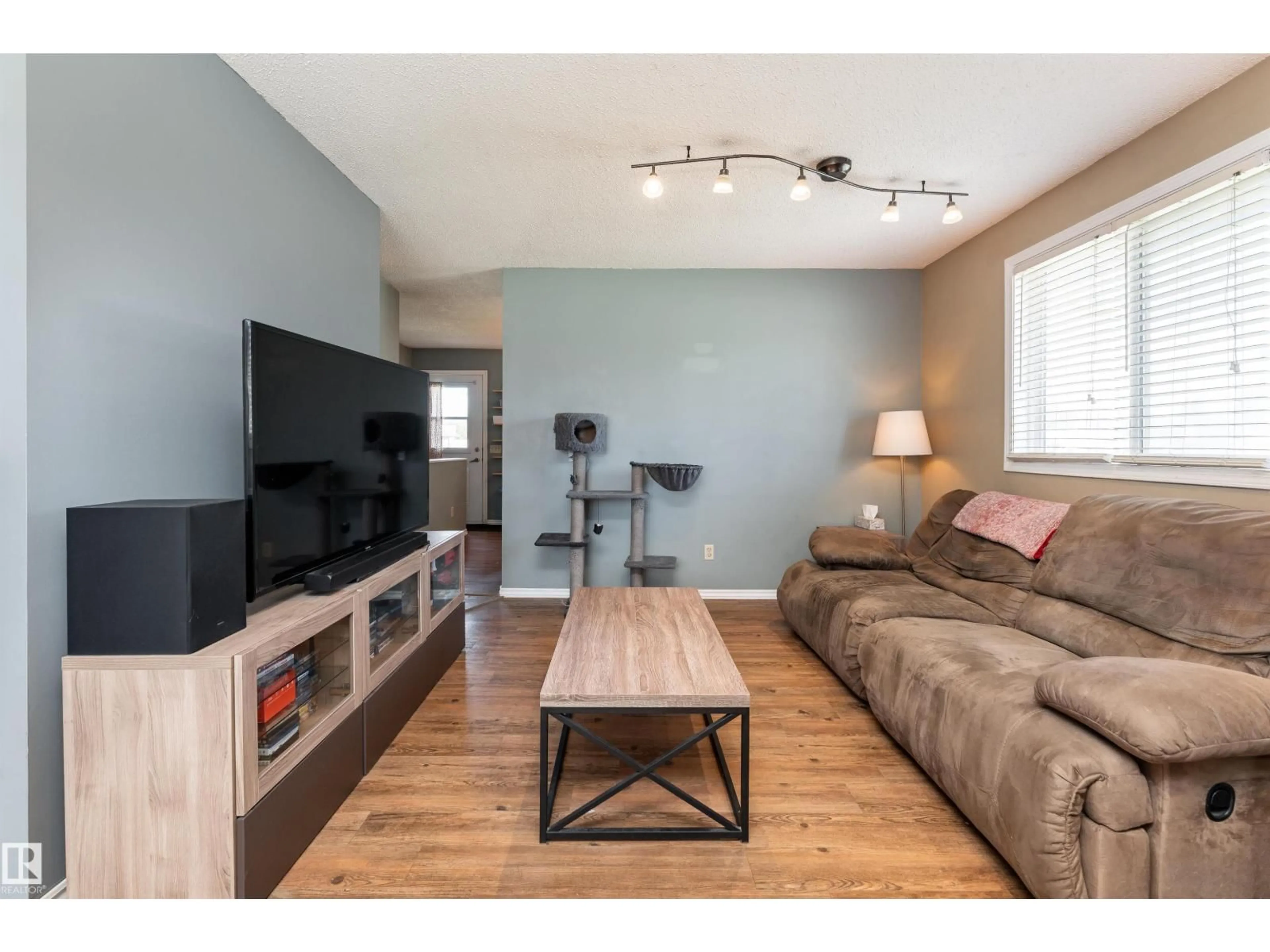 Living room with furniture, wood/laminate floor for #118 - 8930 99 AV, Fort Saskatchewan Alberta T8L3L1
