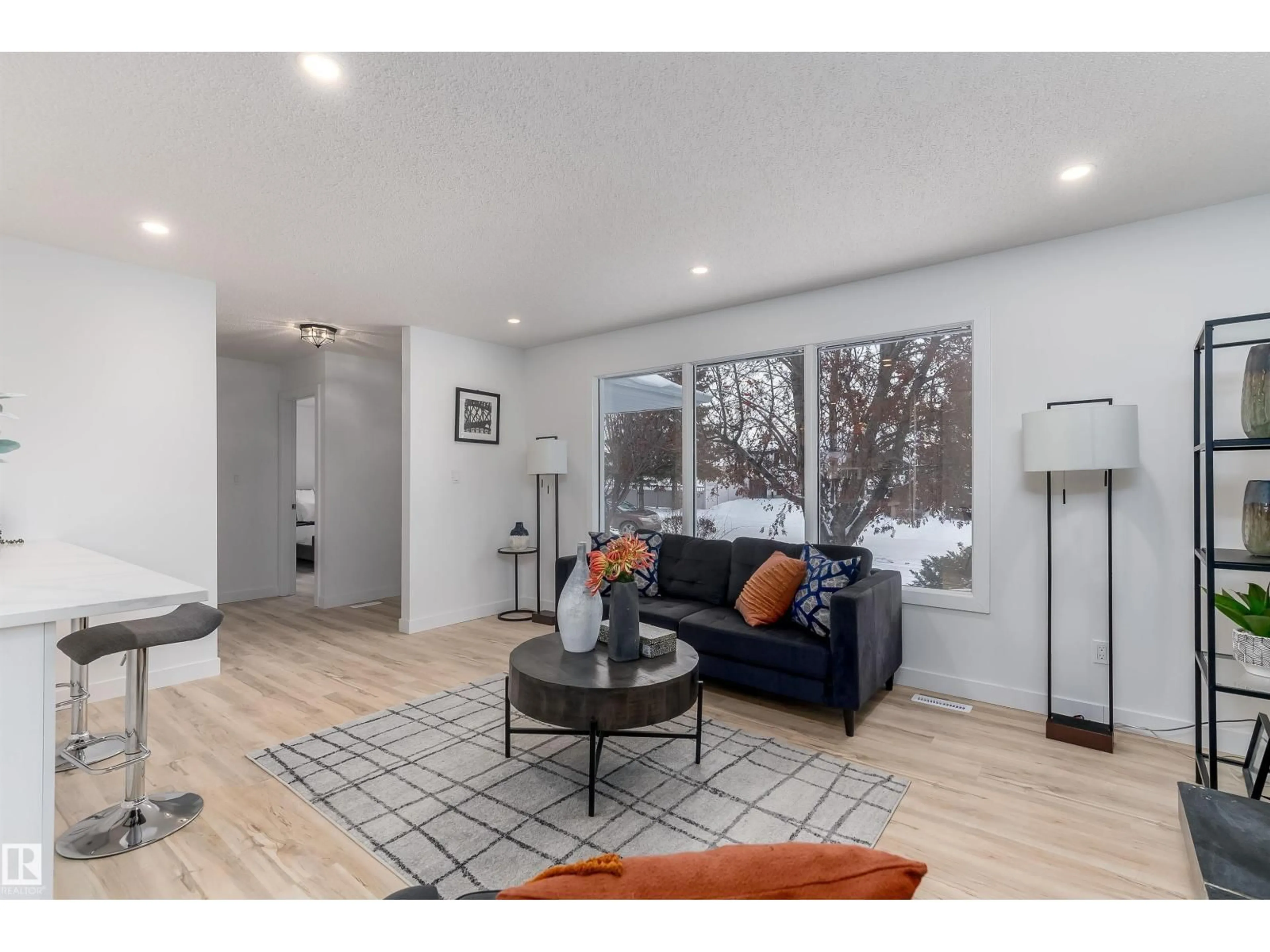 Living room with furniture, wood/laminate floor for 8104 17 AV, Edmonton Alberta T6K2C8