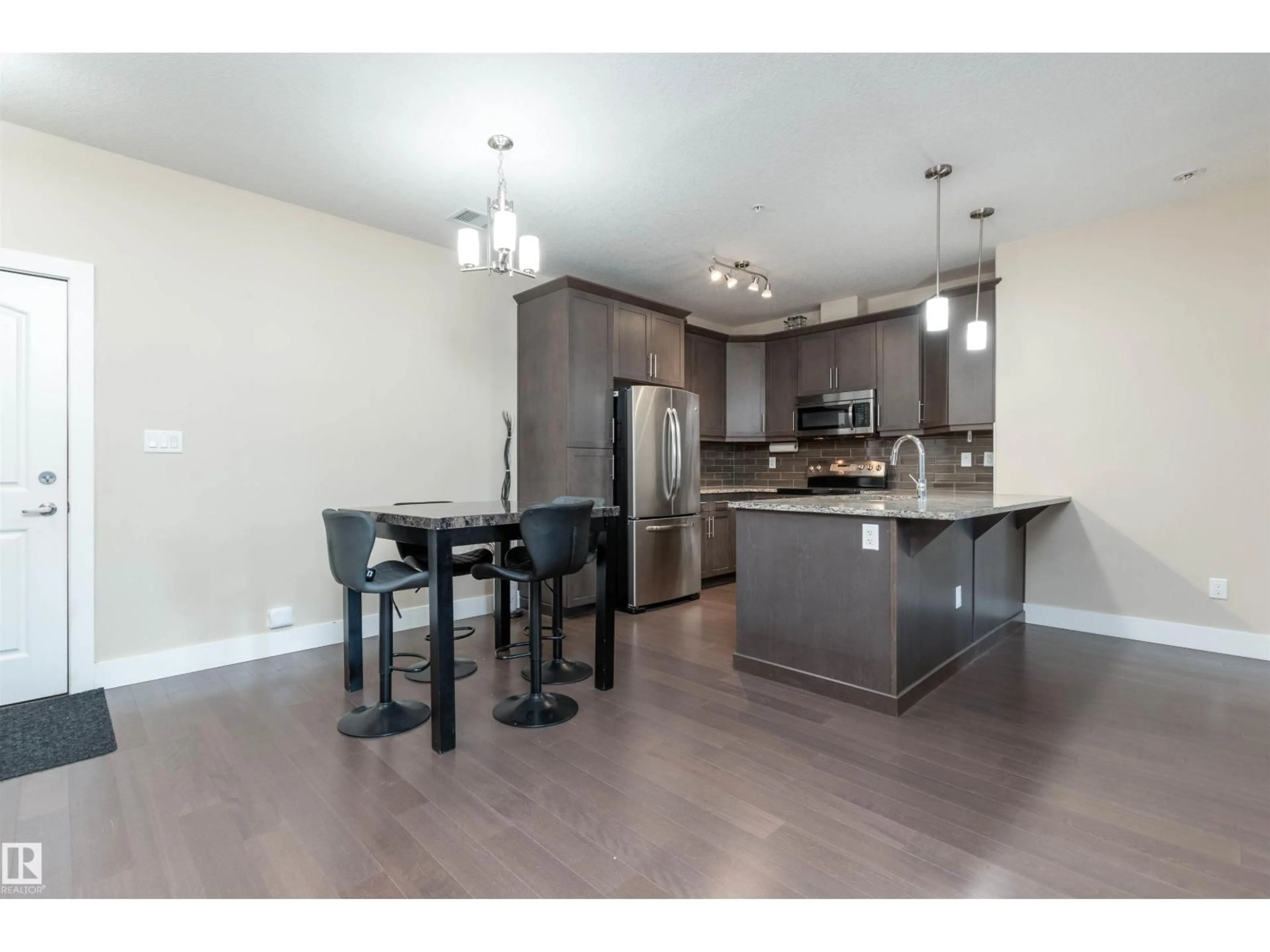 Open concept kitchen, wood/laminate floor for #140 - 6079 MAYNARD WY, Edmonton Alberta T6R0S4