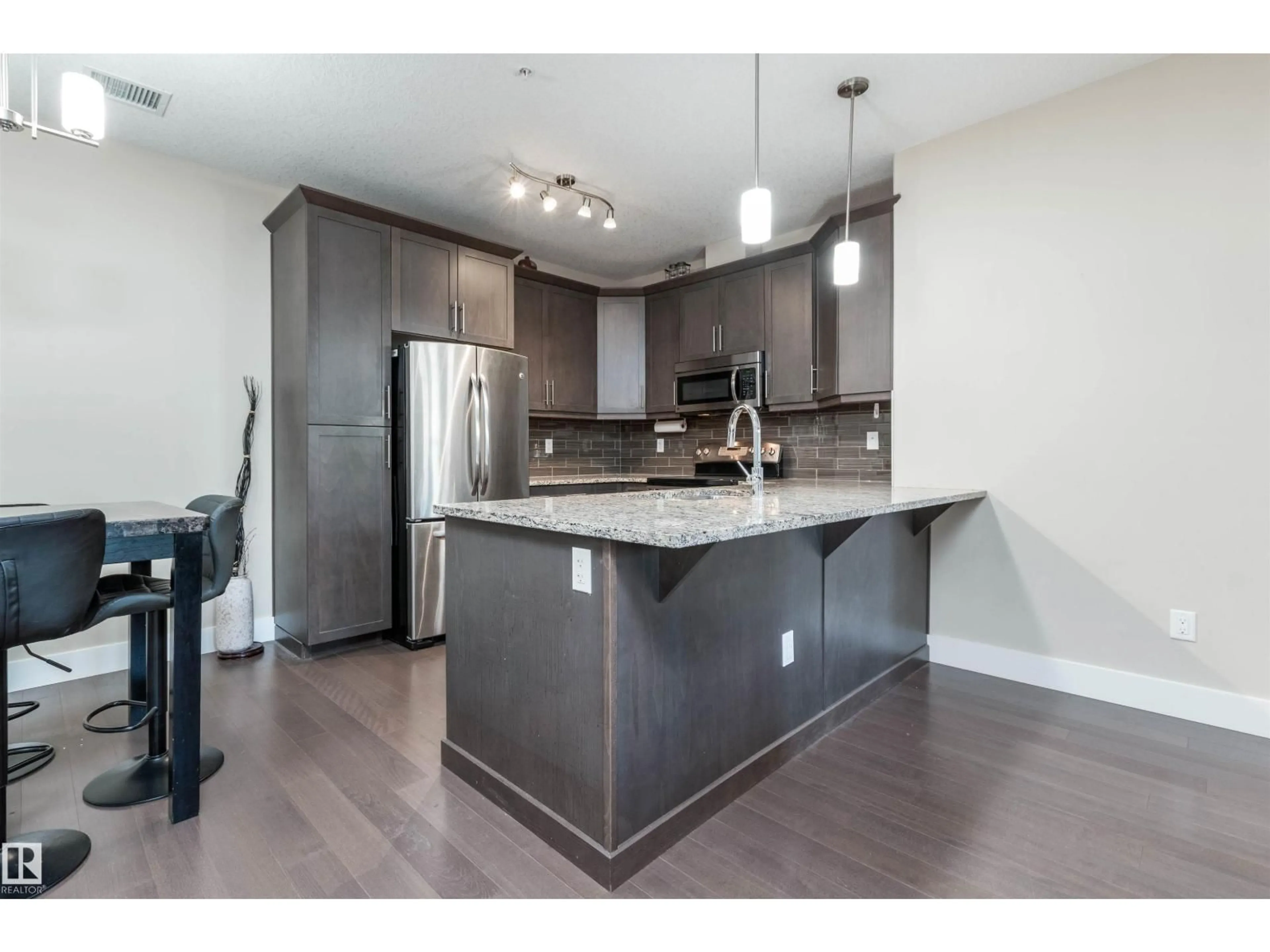 Open concept kitchen, wood/laminate floor for #140 - 6079 MAYNARD WY, Edmonton Alberta T6R0S4