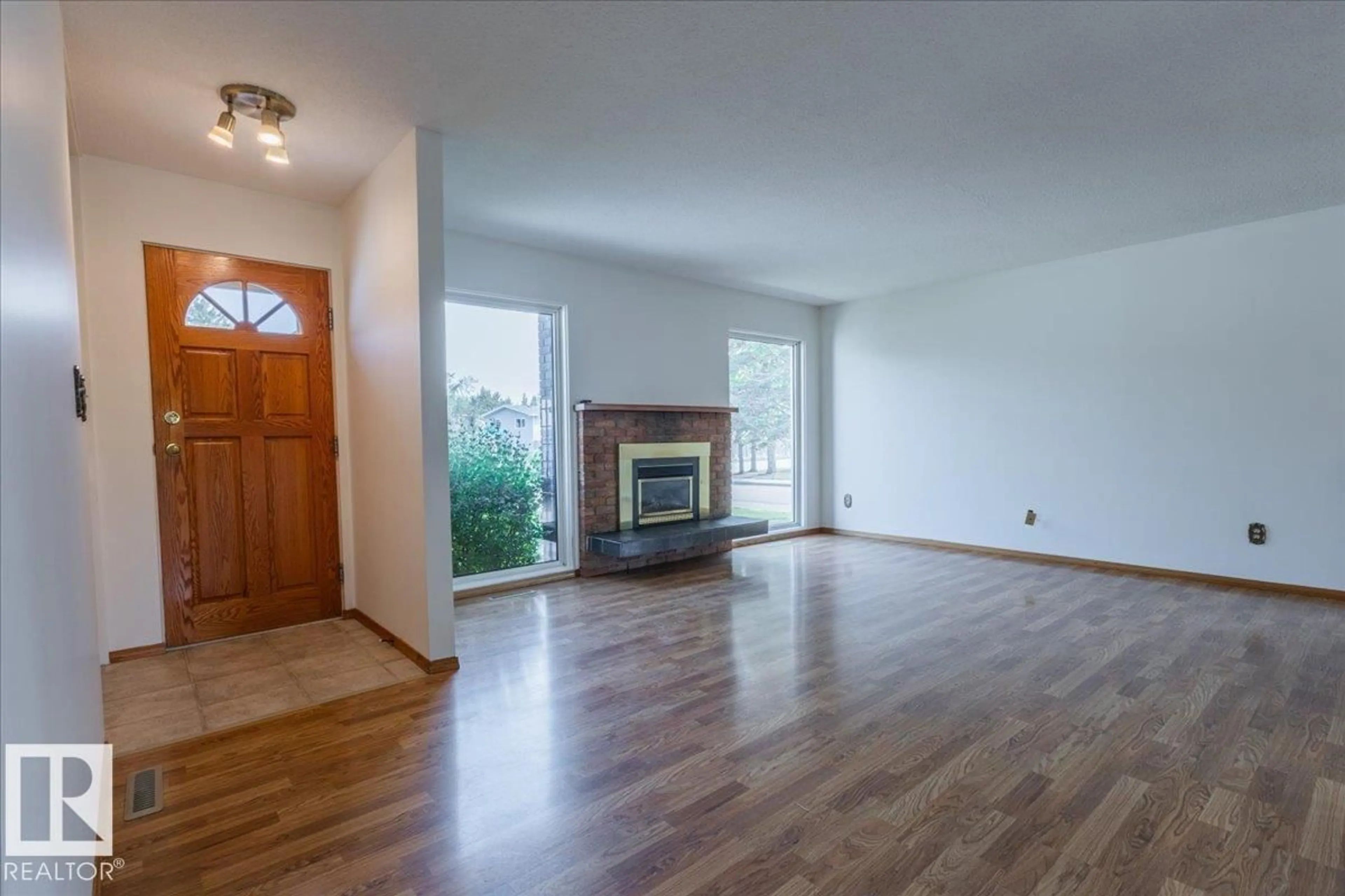 Living room with furniture, wood/laminate floor for 102 MAPLE CR, Wetaskiwin Alberta T9A2E4