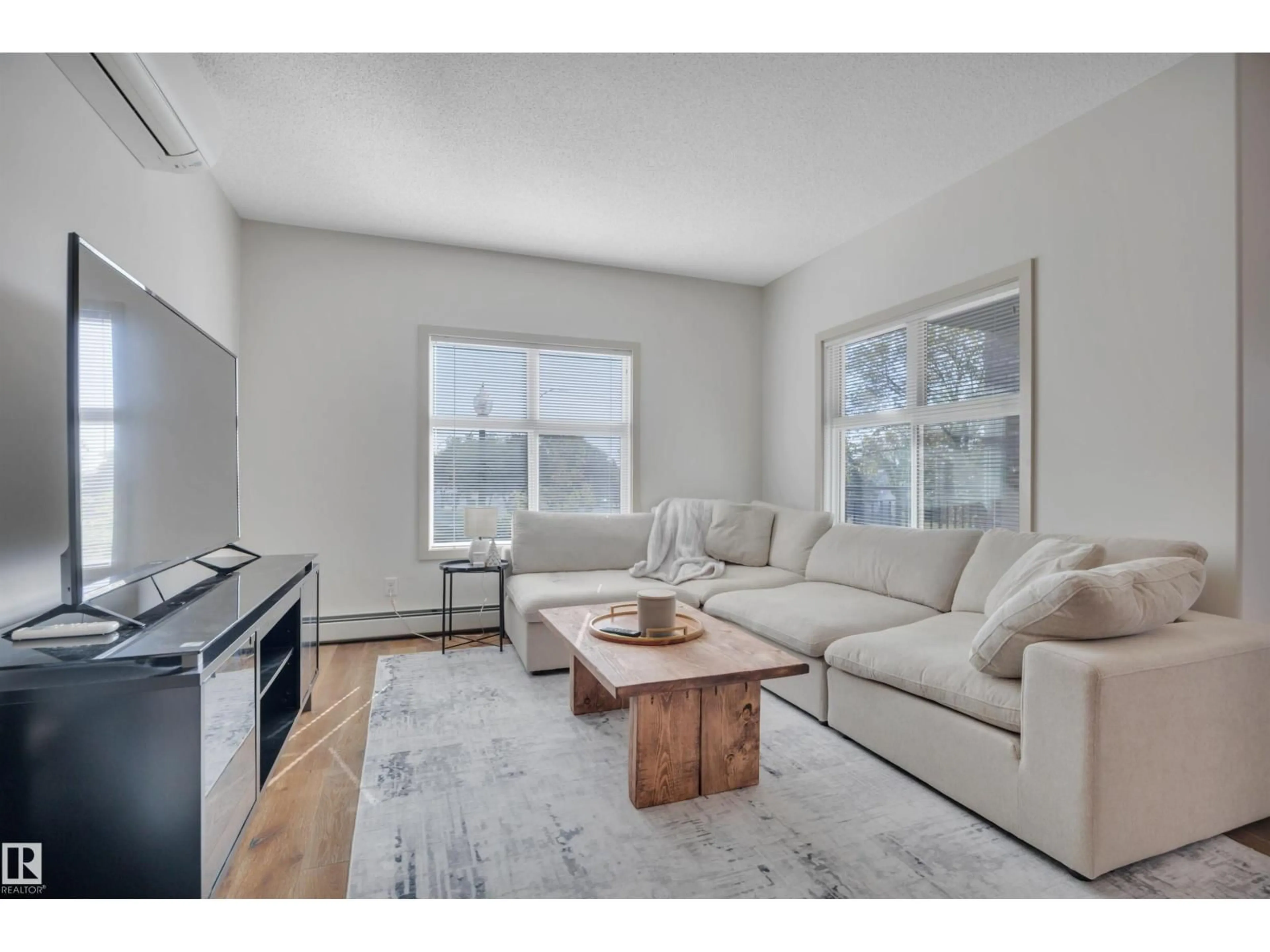 Living room with furniture, wood/laminate floor for #213 - 504 GRIESBACH PARADE, Edmonton Alberta T5E6V9