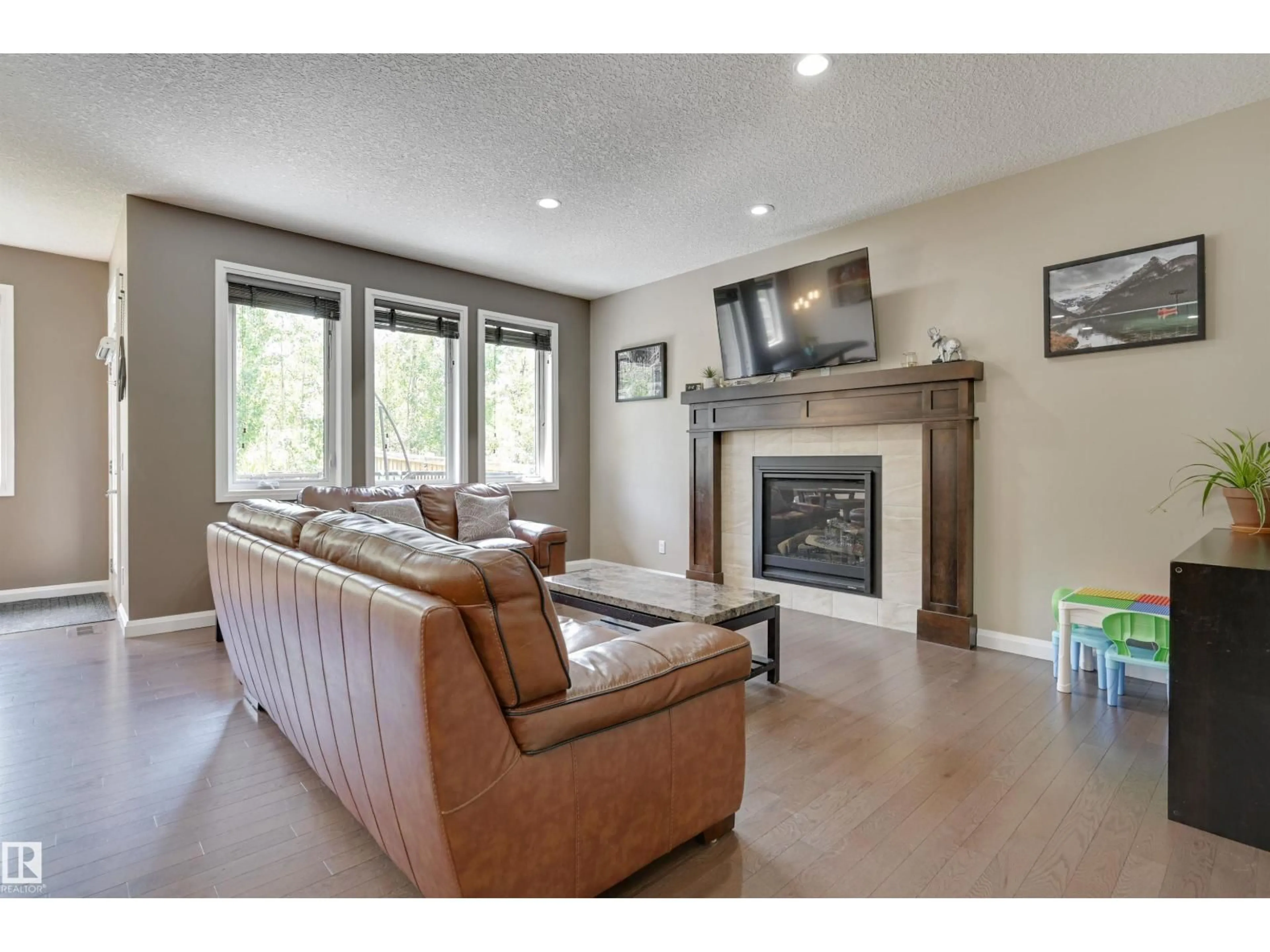 Living room with furniture, wood/laminate floor for NW - 6127 175 AV, Edmonton Alberta T5Y3N7