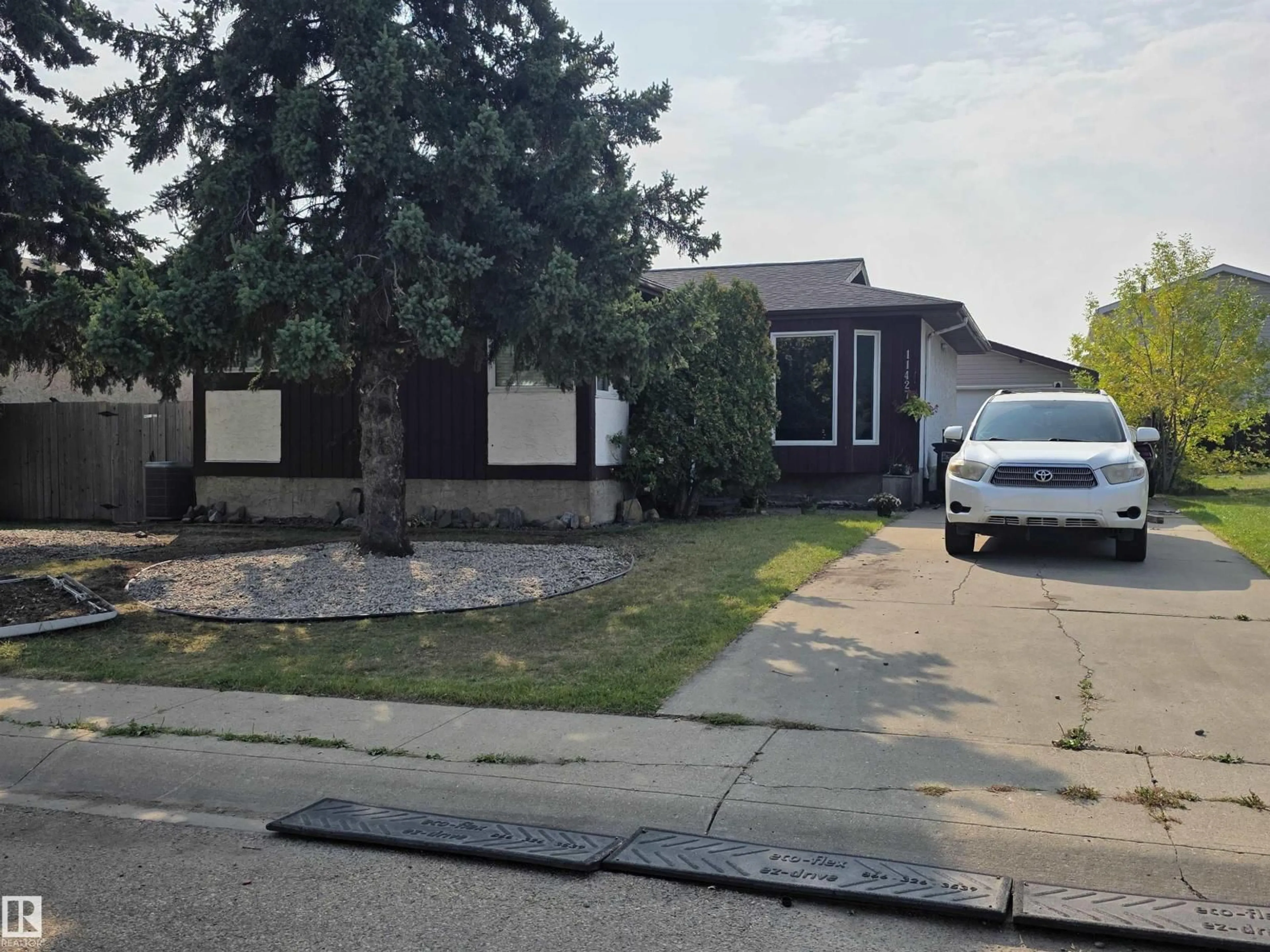 Home with vinyl exterior material, street for 11427 141 AV, Edmonton Alberta T5X3Z7