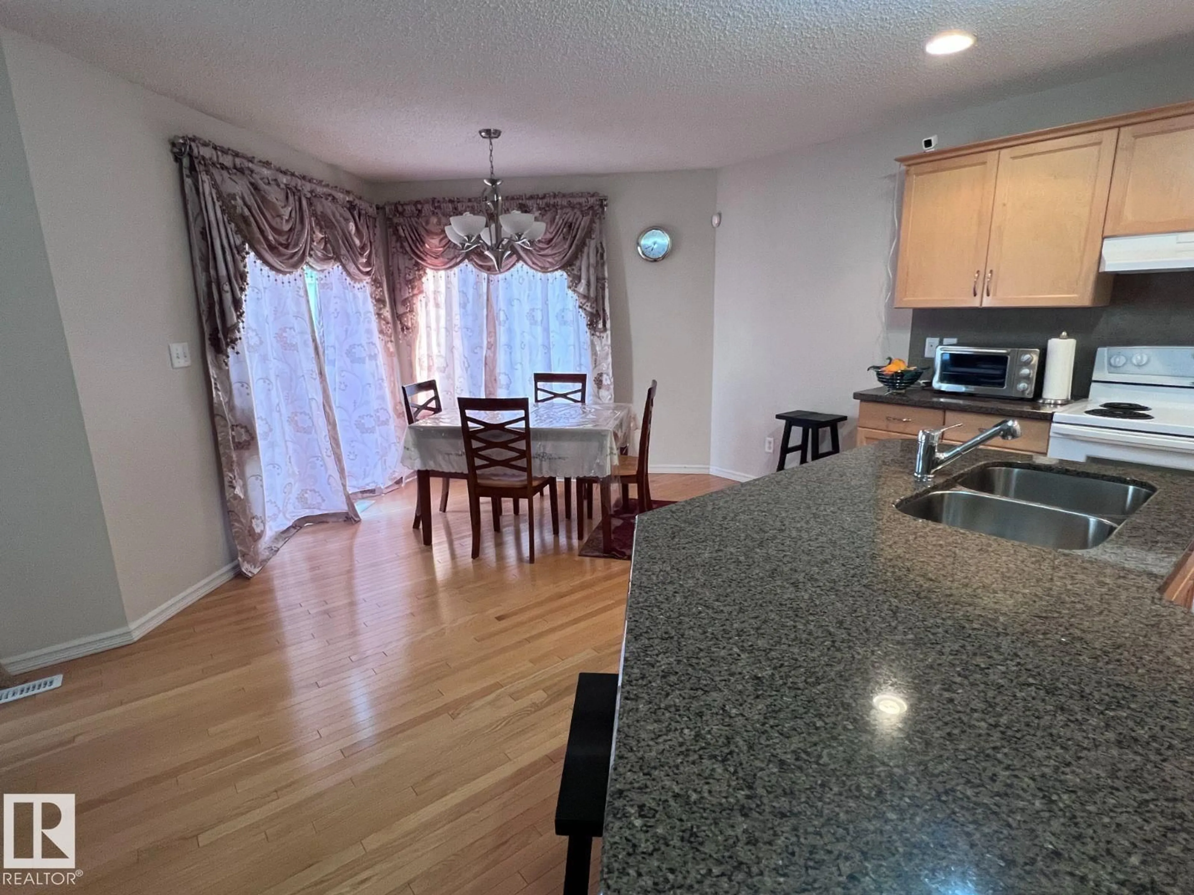Open concept kitchen, wood/laminate floor for 20707 56 AV, Edmonton Alberta T6M0B7