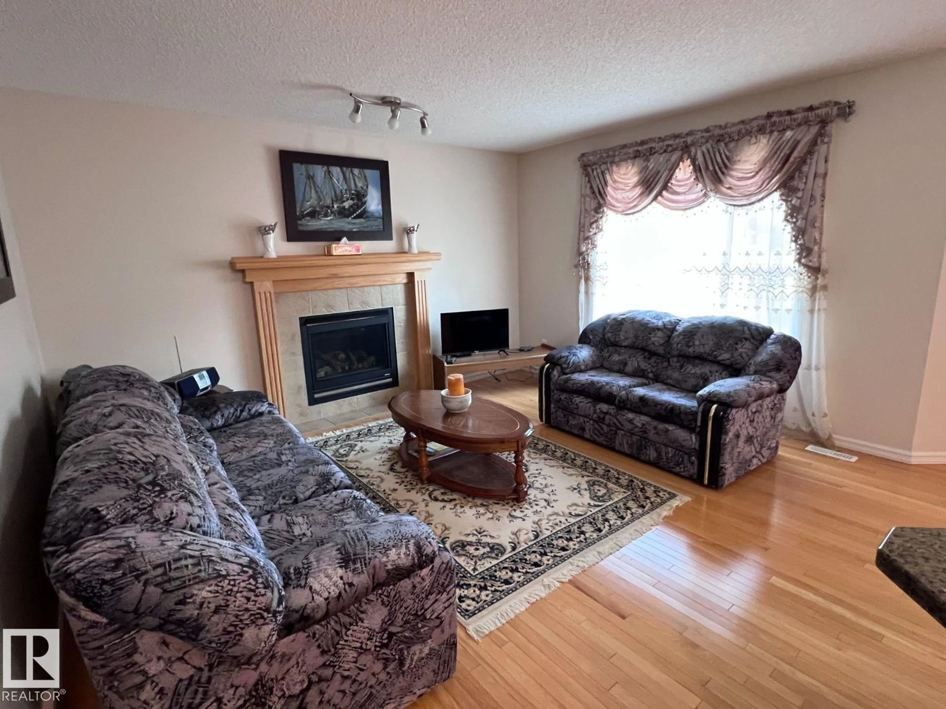Living room with furniture, wood/laminate floor for 20707 56 AV, Edmonton Alberta T6M0B7