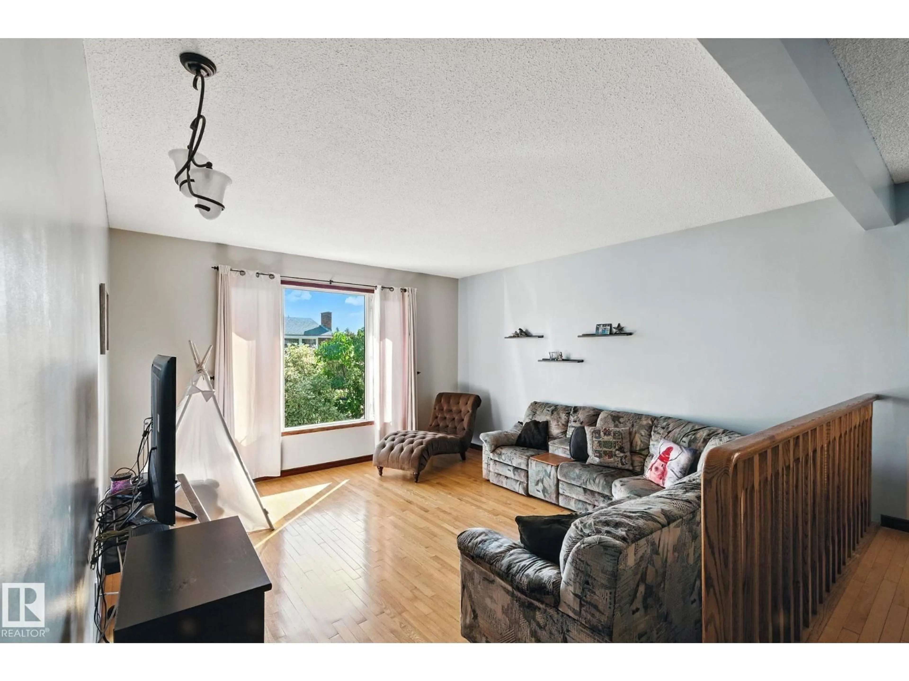 Living room with furniture, wood/laminate floor for 11716 148 AV, Edmonton Alberta T5X1B6