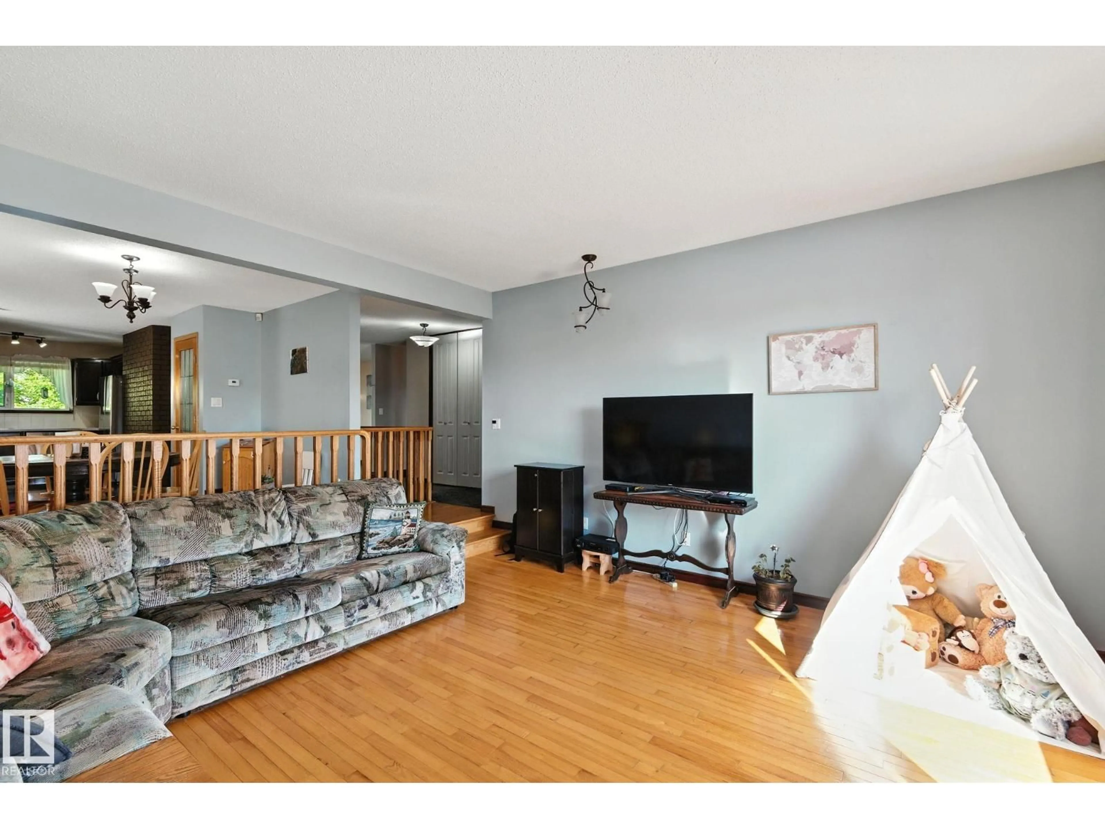 Living room with furniture, wood/laminate floor for 11716 148 AV, Edmonton Alberta T5X1B6