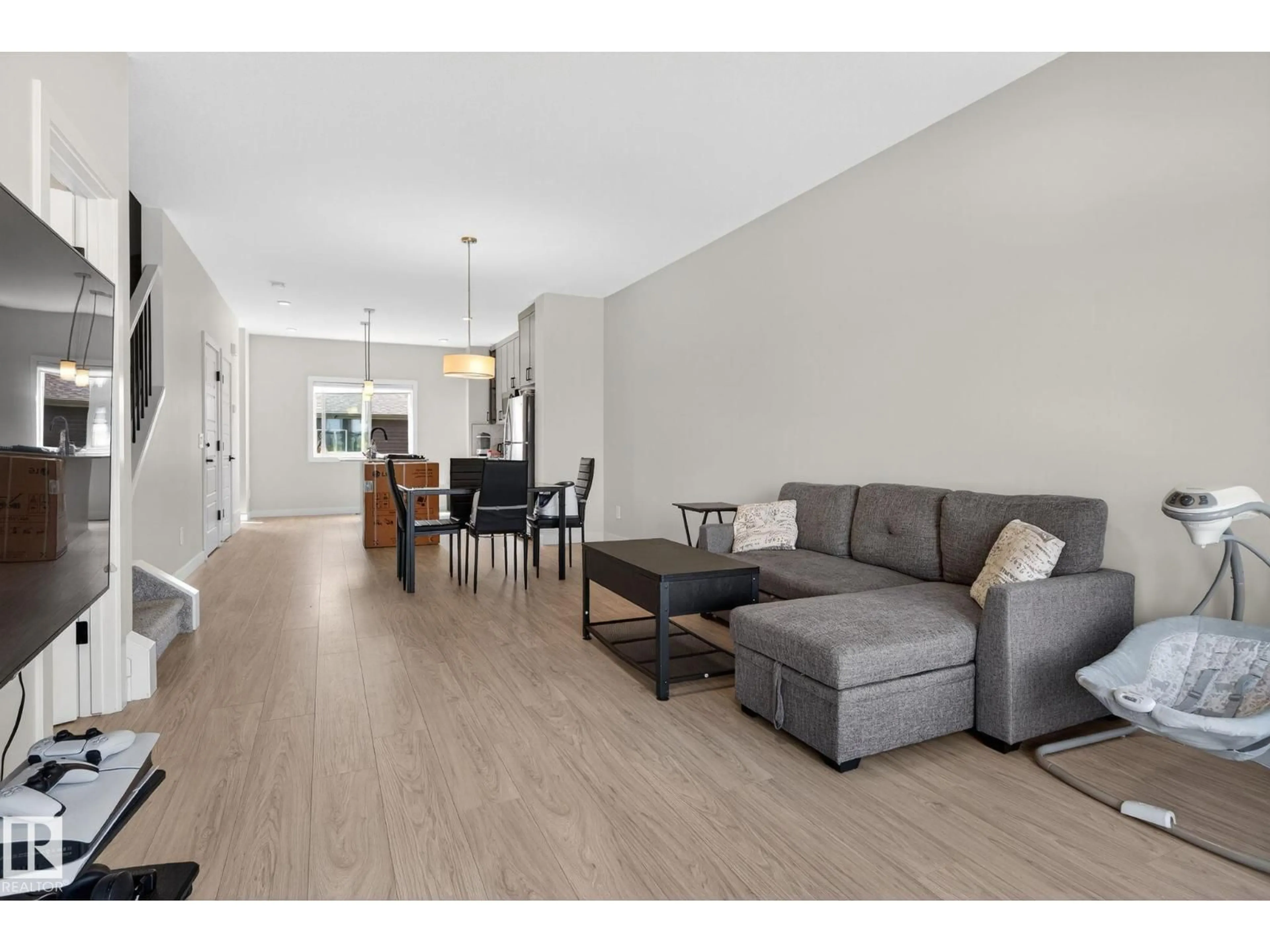 Living room with furniture, wood/laminate floor for NW - 7133/35/37 178 AV, Edmonton Alberta T5Z0T8