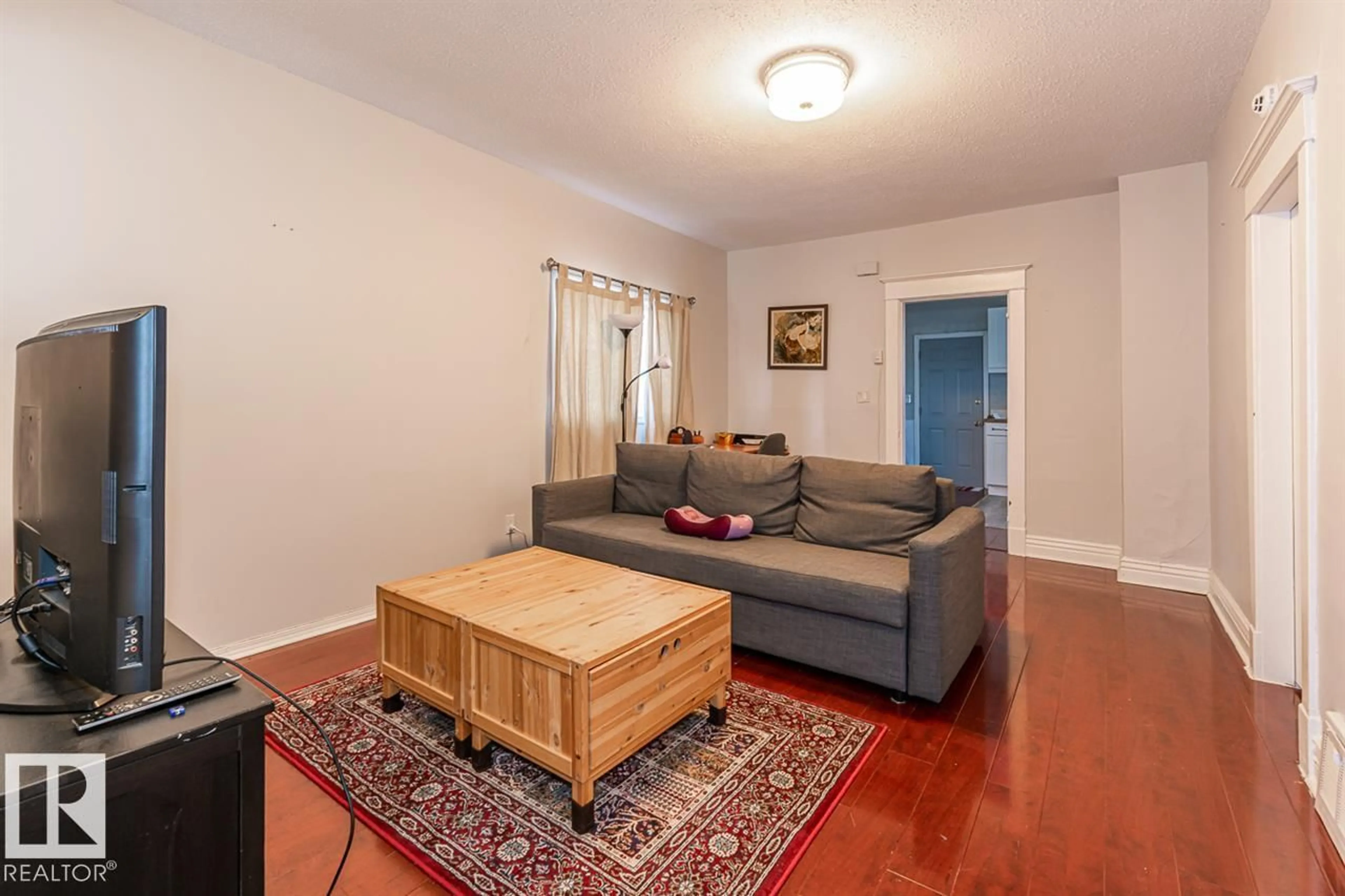 Living room with furniture, wood/laminate floor for 9332 106A AV, Edmonton Alberta T5H0S7
