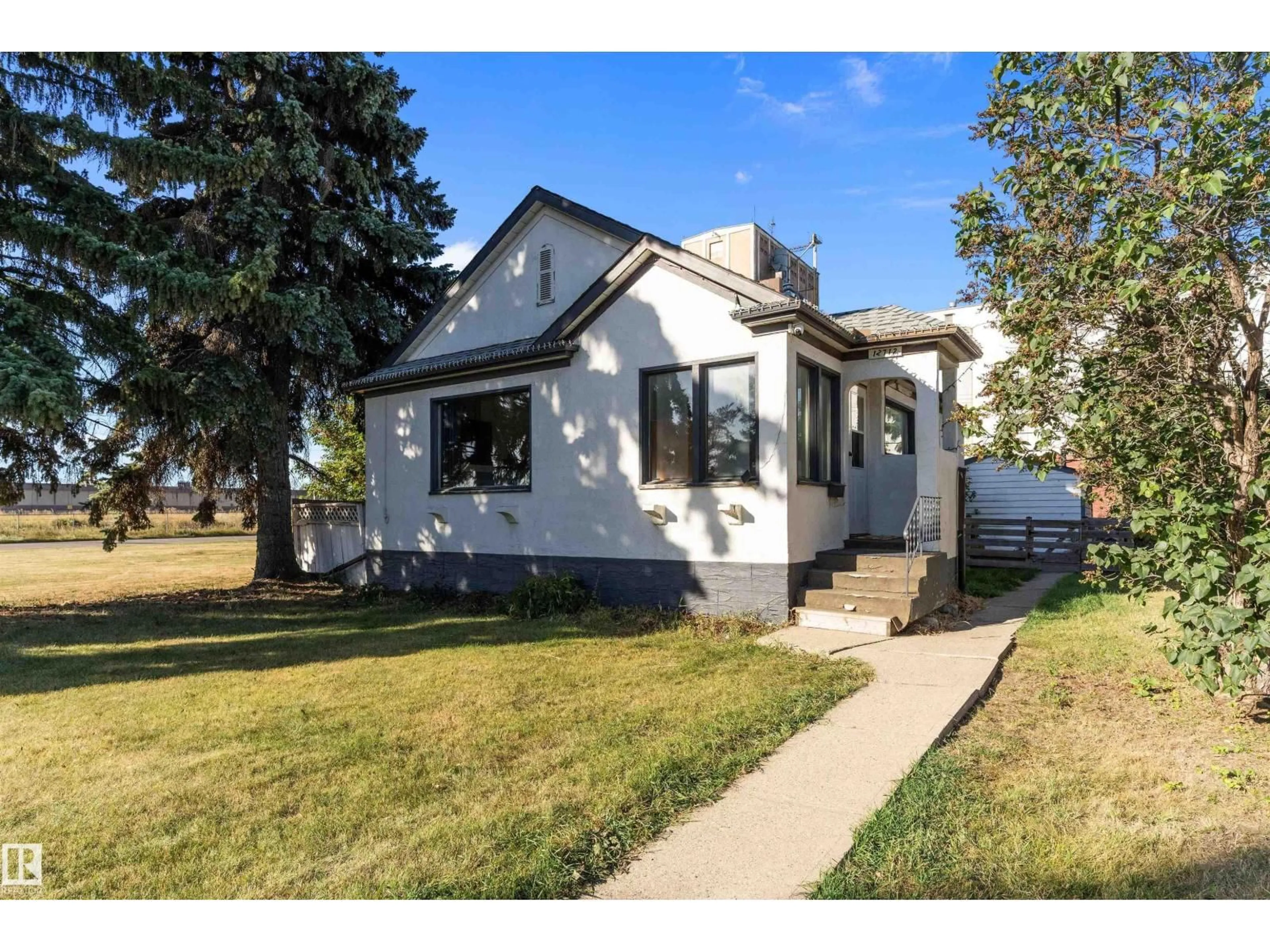 Home with vinyl exterior material, street for 12712 130 ST, Edmonton Alberta T5L1L2