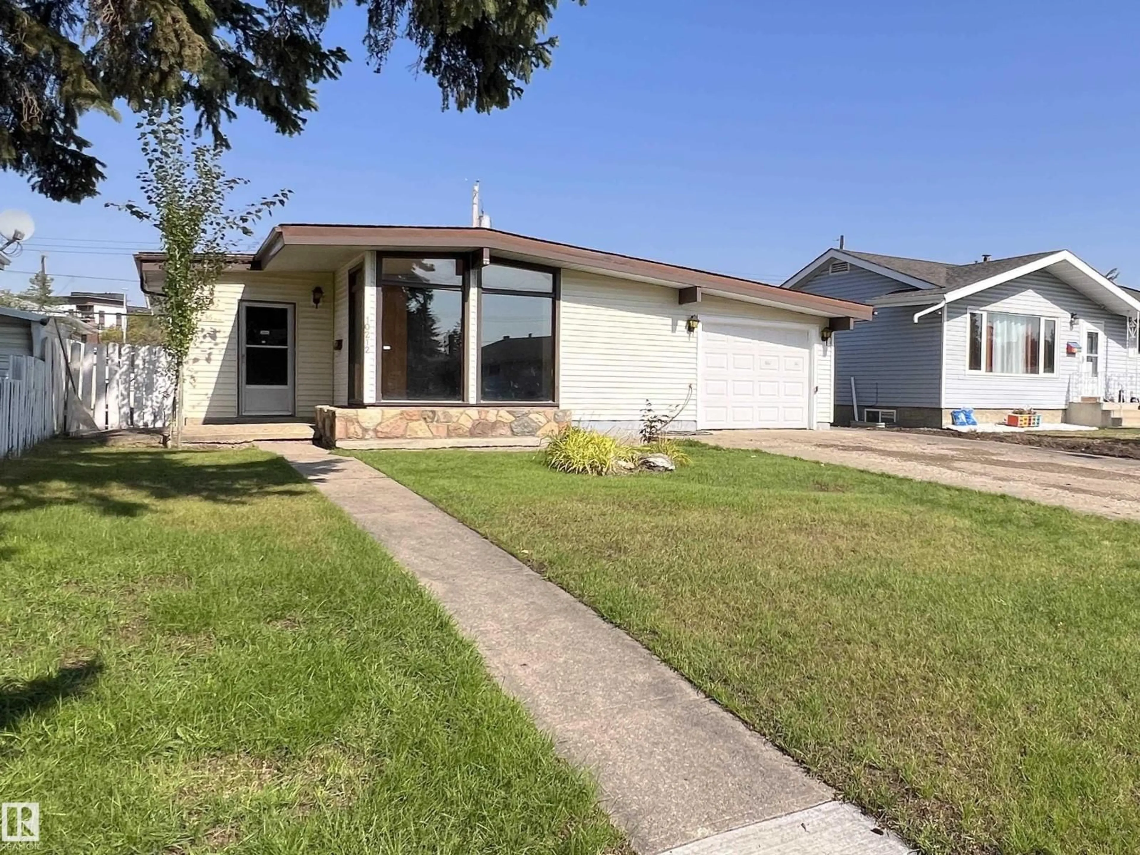 Home with vinyl exterior material, street for 10212 136 AV, Edmonton Alberta T5E1W1