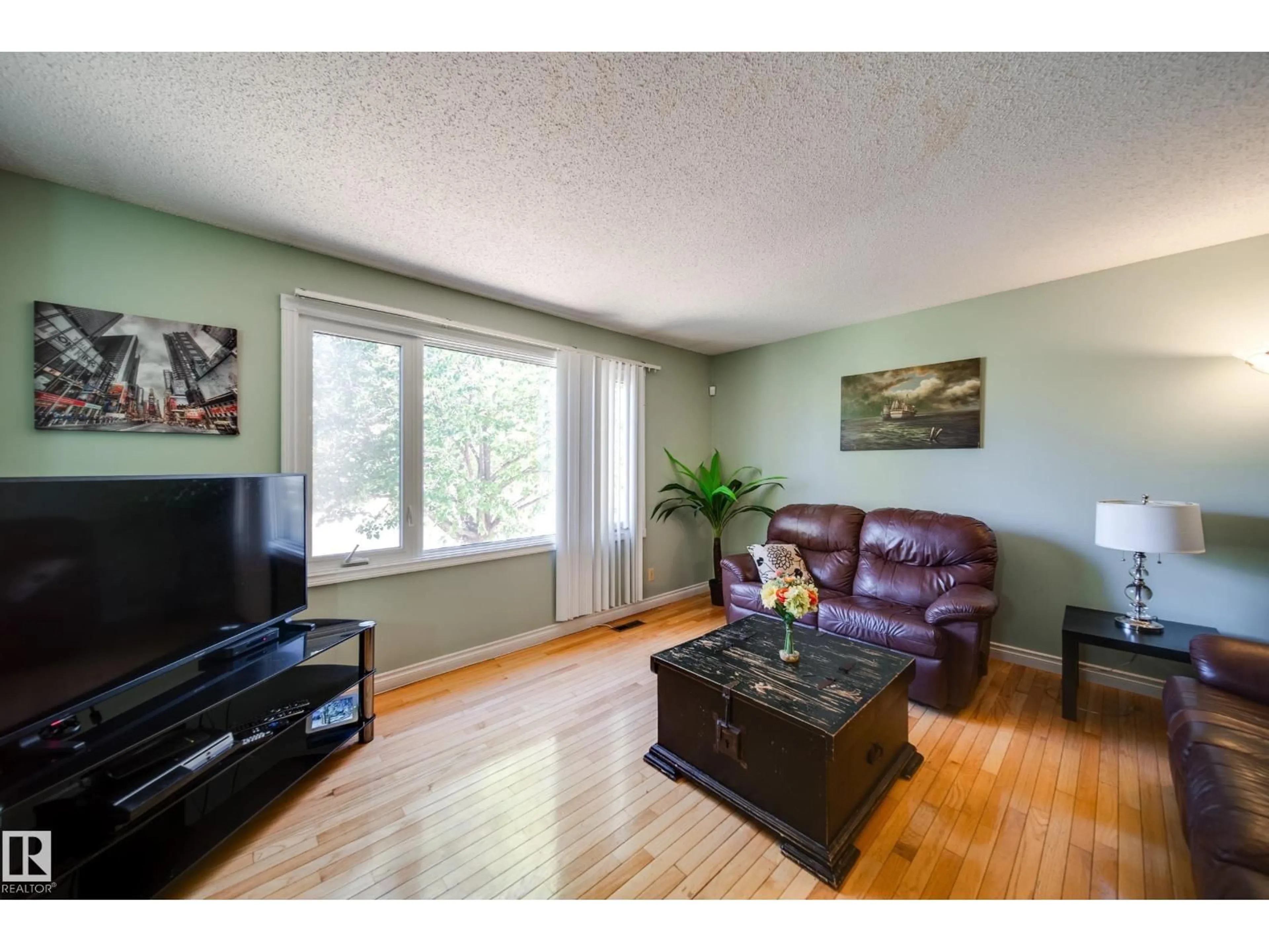 Living room with furniture, wood/laminate floor for 102 WOODVALE RD, Edmonton Alberta T6L1P7