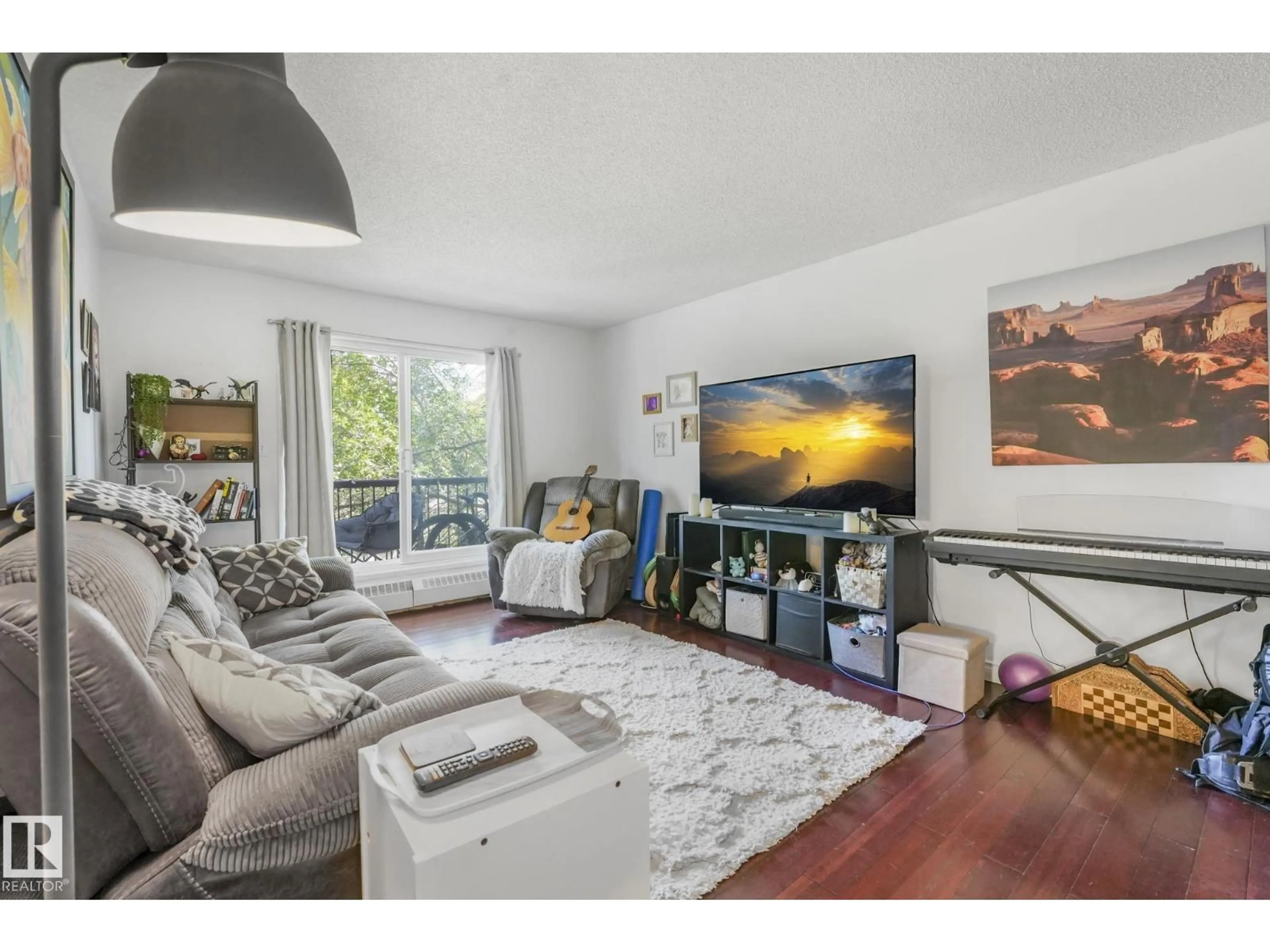 Living room with furniture, wood/laminate floor for #309 - 10636 120 ST, Edmonton Alberta T5H4L5