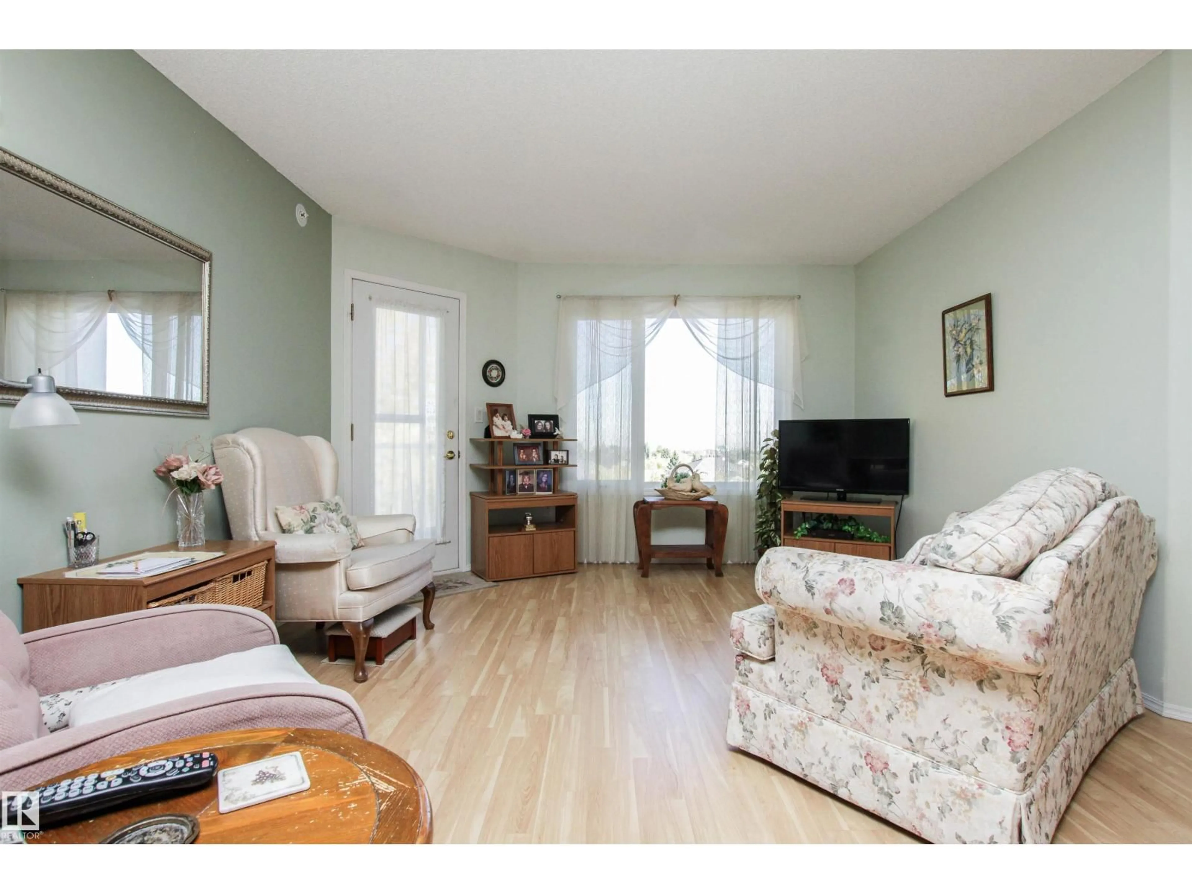 Living room with furniture, wood/laminate floor for 69 - 404 CRYSTAL LN, Sherwood Park Alberta T8H2E9