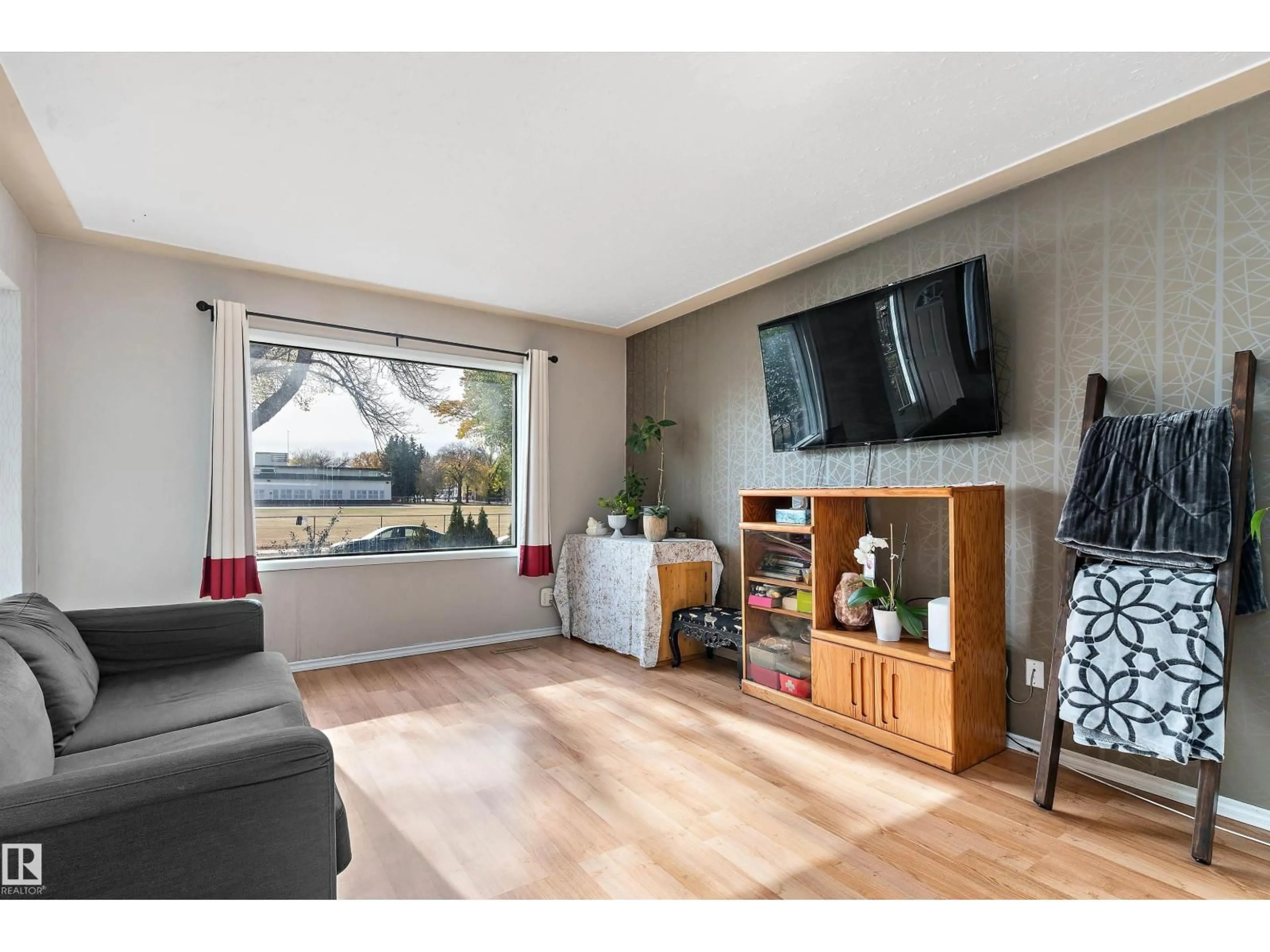 Living room with furniture, wood/laminate floor for 10570 66 AV, Edmonton Alberta T6H1X4