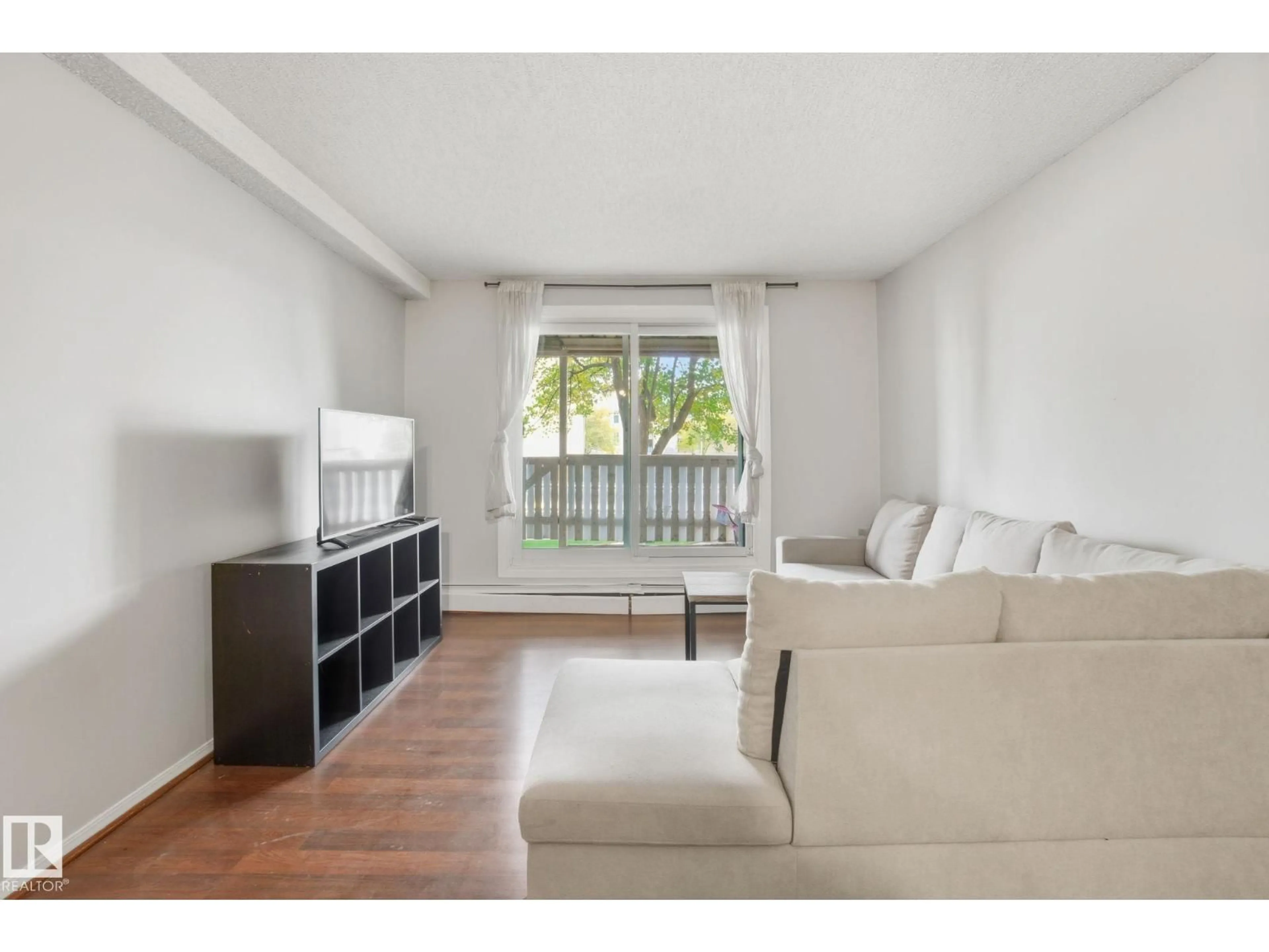 Living room with furniture, wood/laminate floor for 106 - 4810 MILL WOODS RD S, Edmonton Alberta T6L5N9