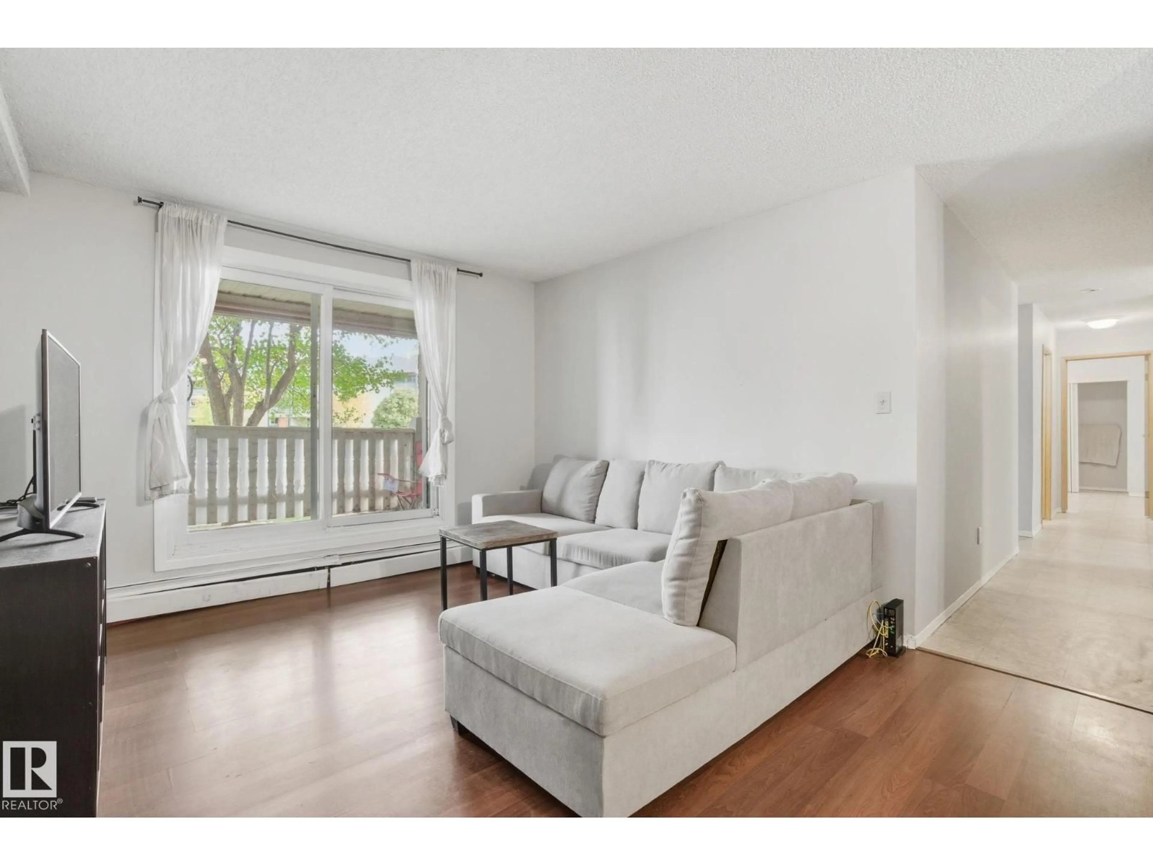 Living room with furniture, wood/laminate floor for 106 - 4810 MILL WOODS RD S, Edmonton Alberta T6L5N9