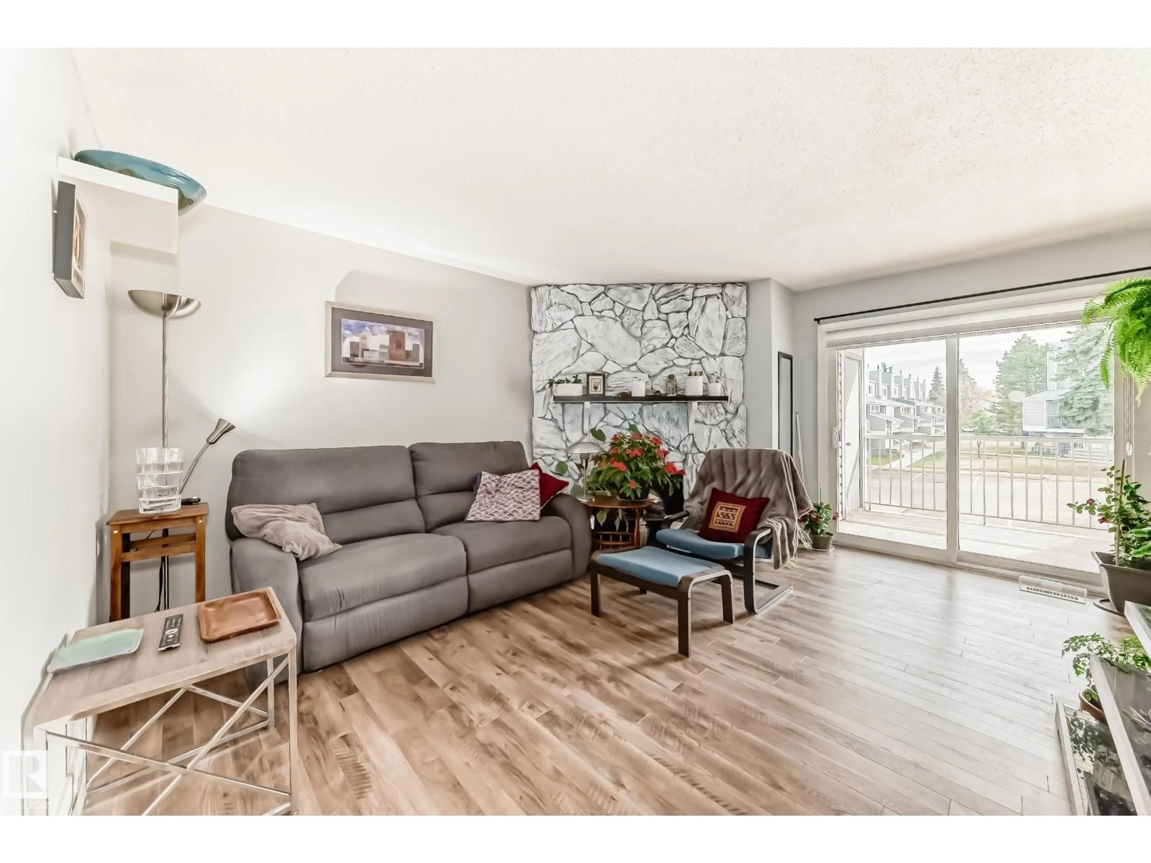 Living room with furniture, wood/laminate floor for 310 - 10404 24 AV, Edmonton Alberta T6J4J7