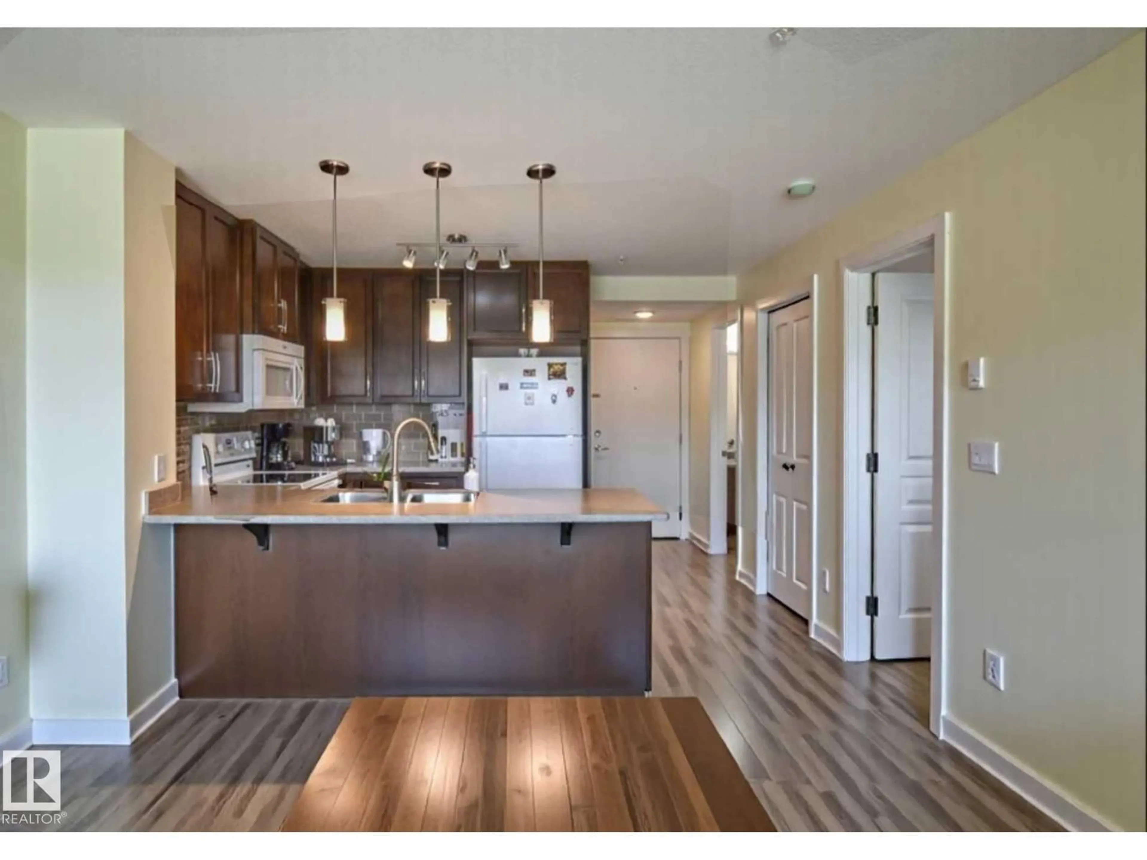 Open concept kitchen, wood/laminate floor for #210 - 3670 139 AV, Edmonton Alberta T5Y3N5