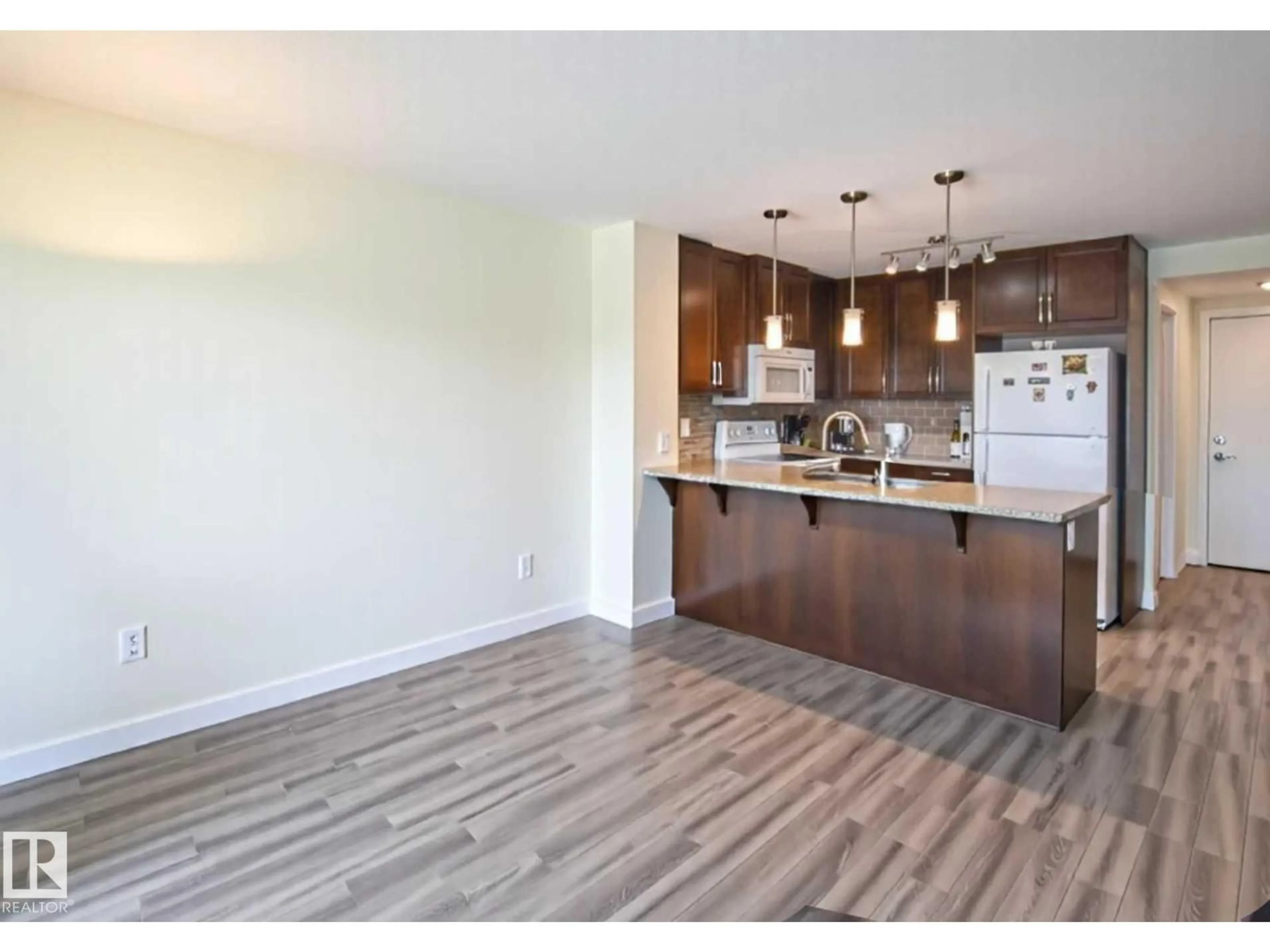 Open concept kitchen, wood/laminate floor for #210 - 3670 139 AV, Edmonton Alberta T5Y3N5