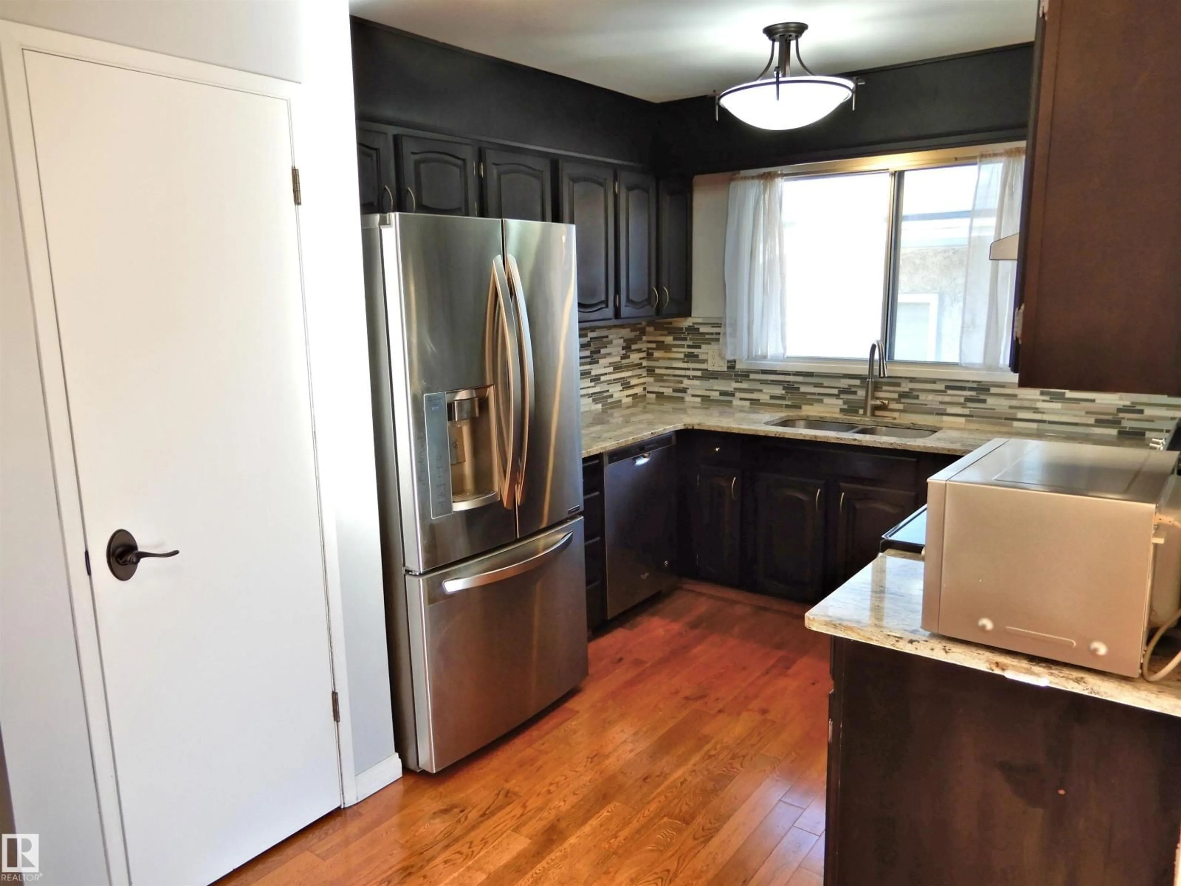 Open concept kitchen, wood/laminate floor for NW - 18617 62B AV, Edmonton Alberta T5T2S8