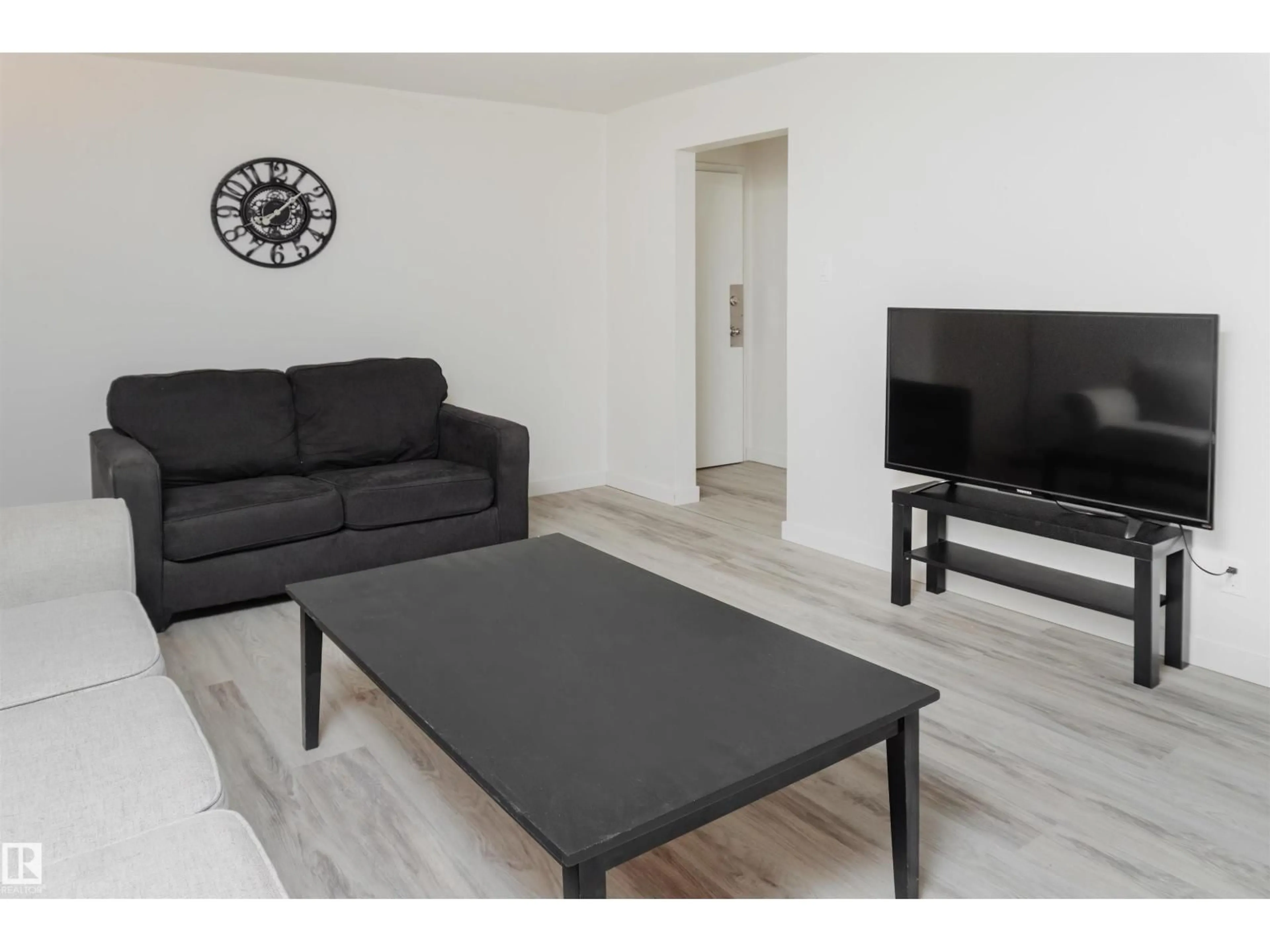 Living room with furniture, wood/laminate floor for 7204 81 AV, Edmonton Alberta T6B0E2
