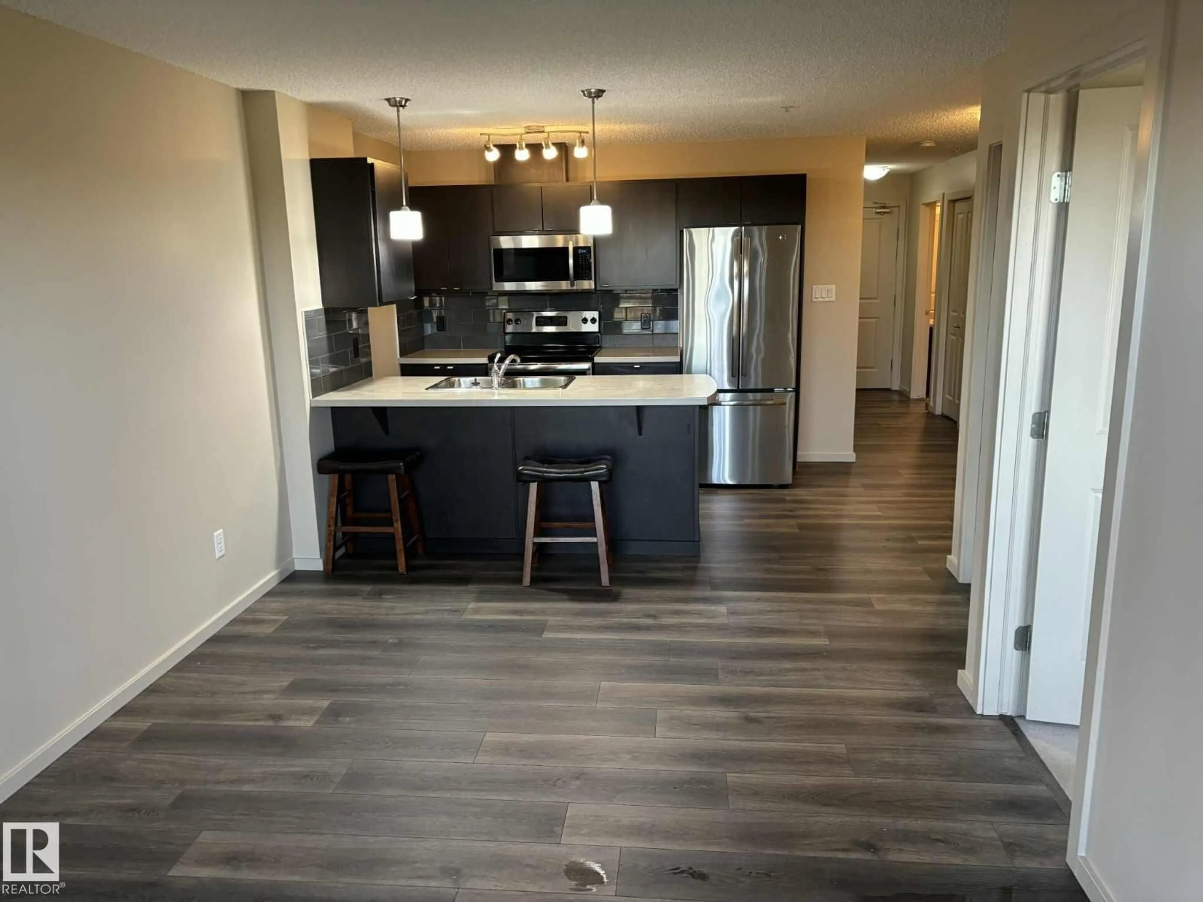 Open concept kitchen, wood/laminate floor for #351 - 1196 HYNDMAN RD, Edmonton Alberta T5A0X8