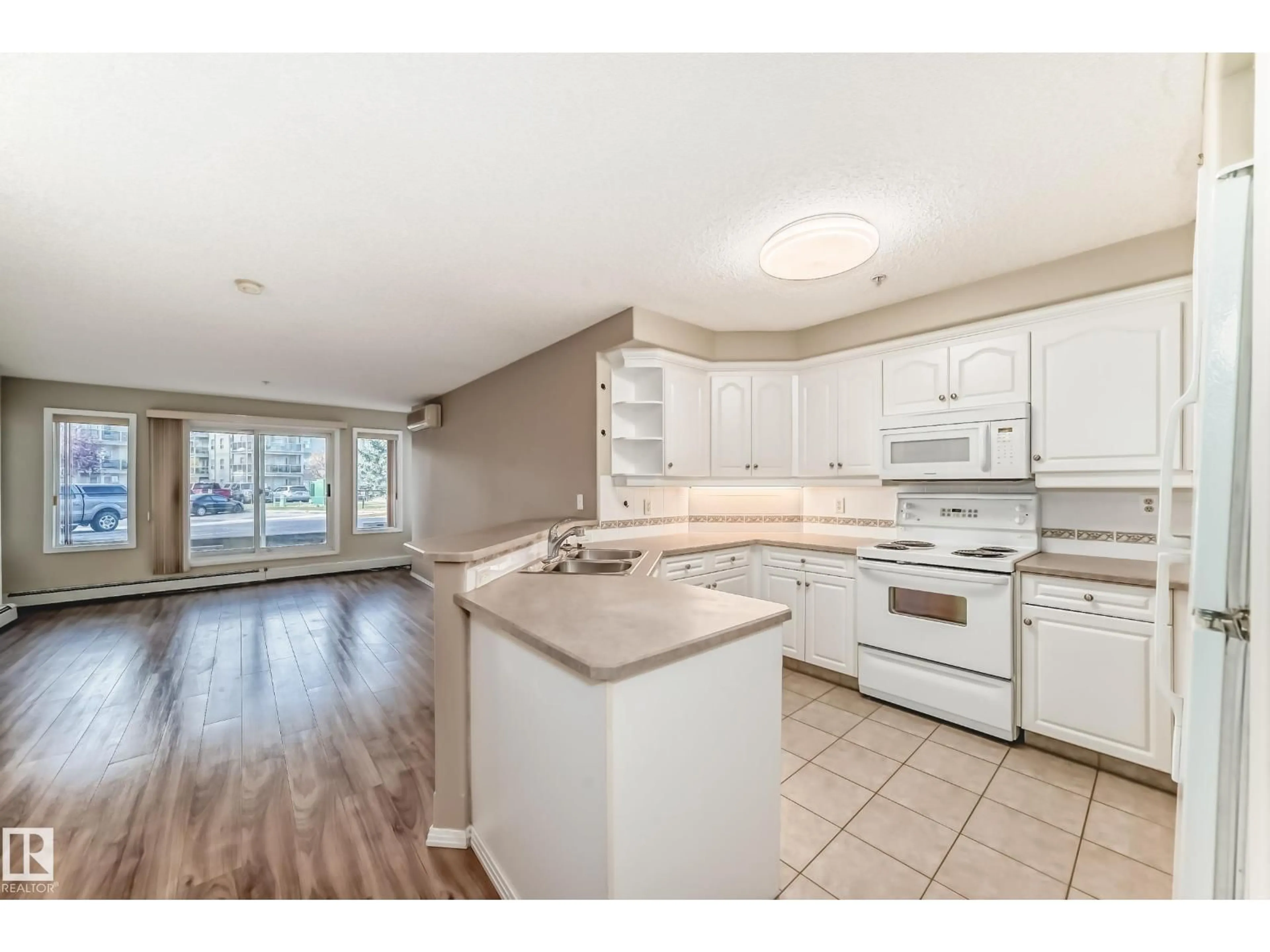 Open concept kitchen, wood/laminate floor for #141 - 9704 174 ST, Edmonton Alberta T5T6J4