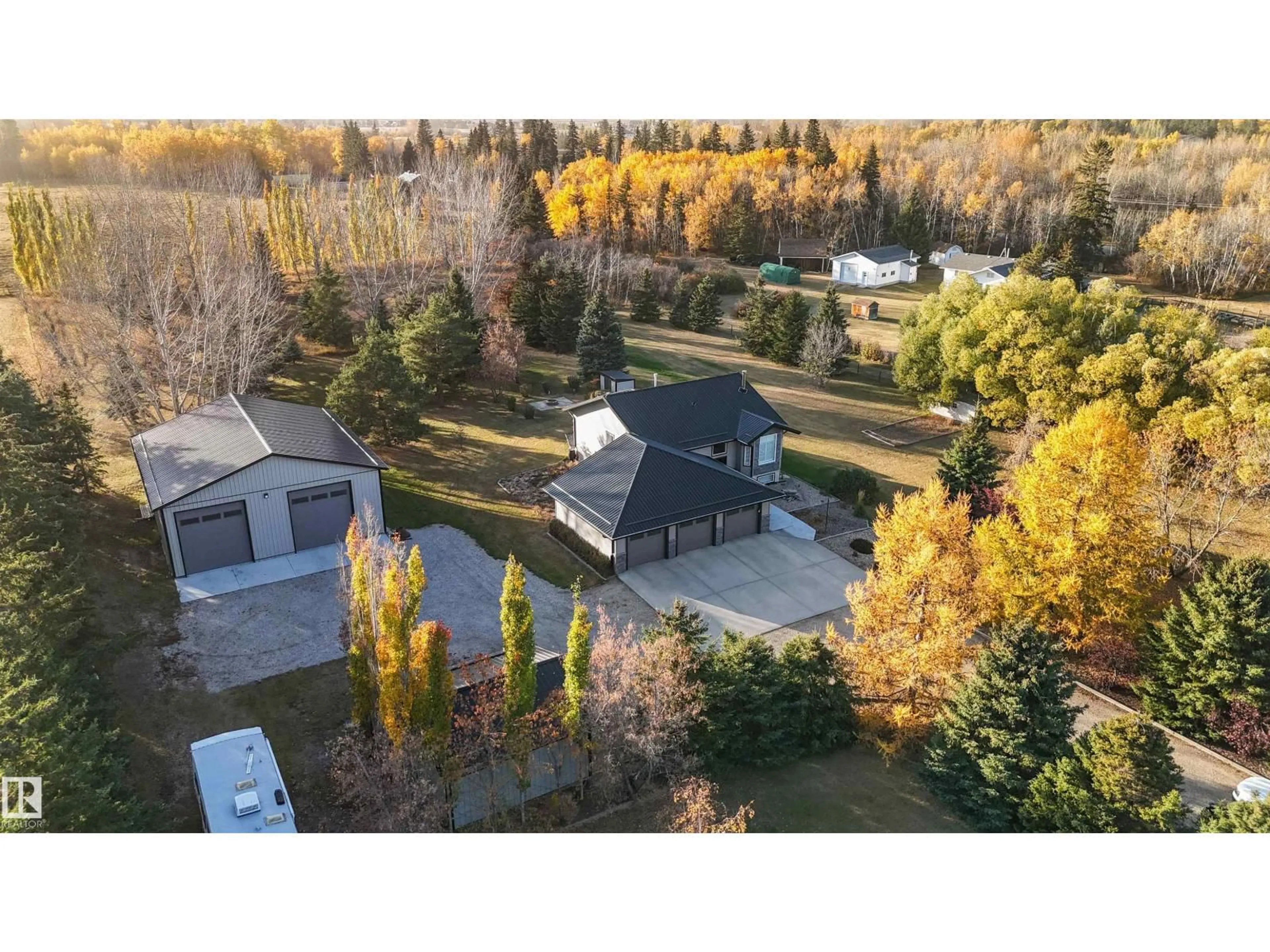 A pic from outside/outdoor area/front of a property/back of a property/a pic from drone, forest/trees view for #4 - 27005 TWP ROAD 511, Rural Parkland County Alberta T7Z1R1
