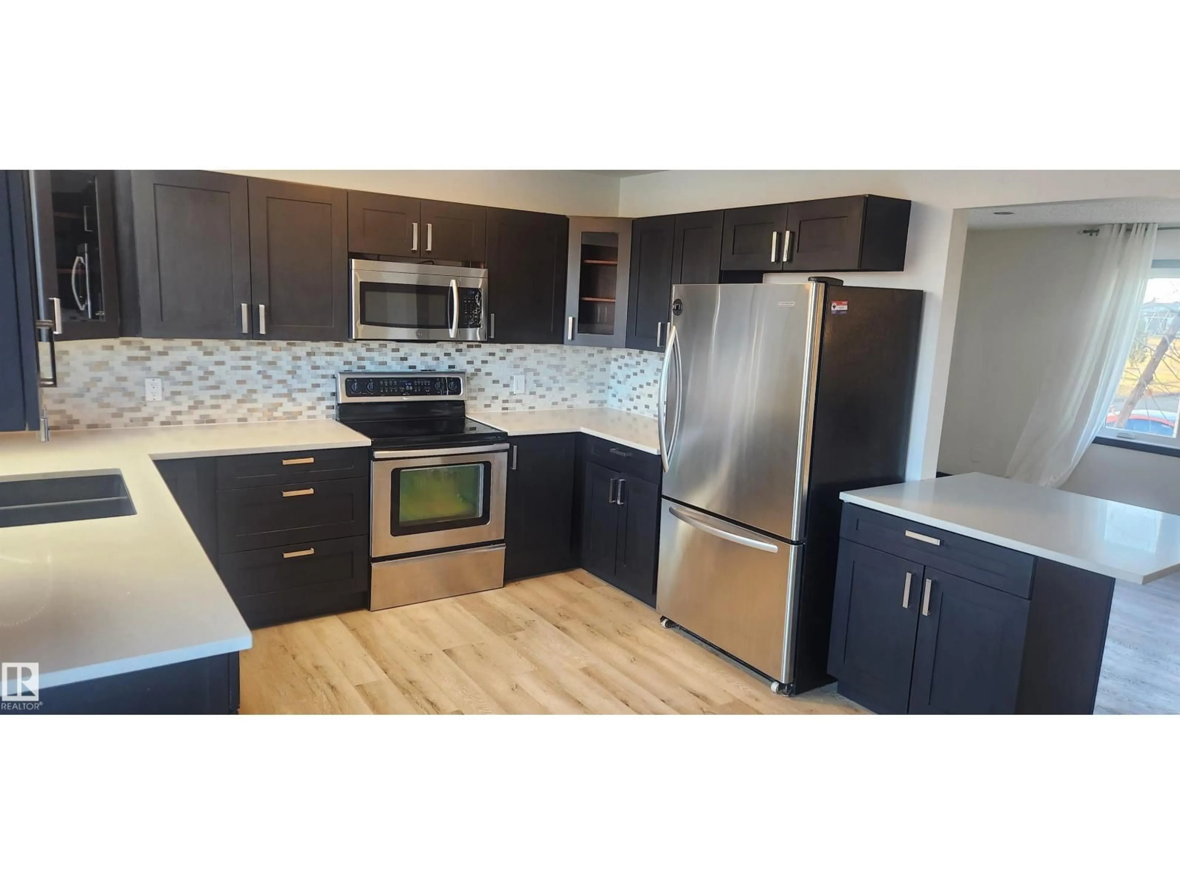 Open concept kitchen, wood/laminate floor for 11007 105 ST, Westlock Alberta T7P1E8