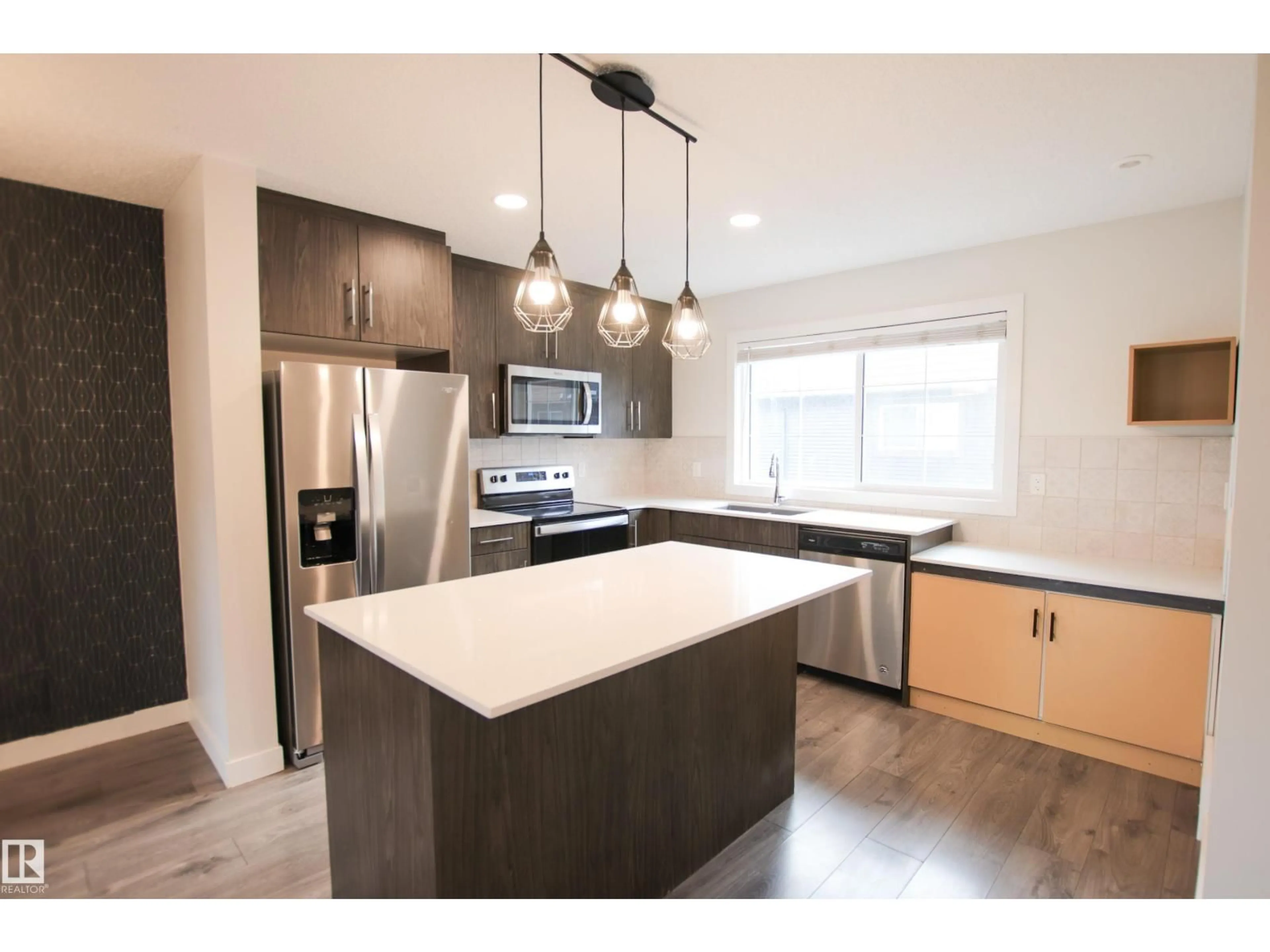 Open concept kitchen, wood/laminate floor for #38 - 3025 151 AV, Edmonton Alberta T5Y3W4
