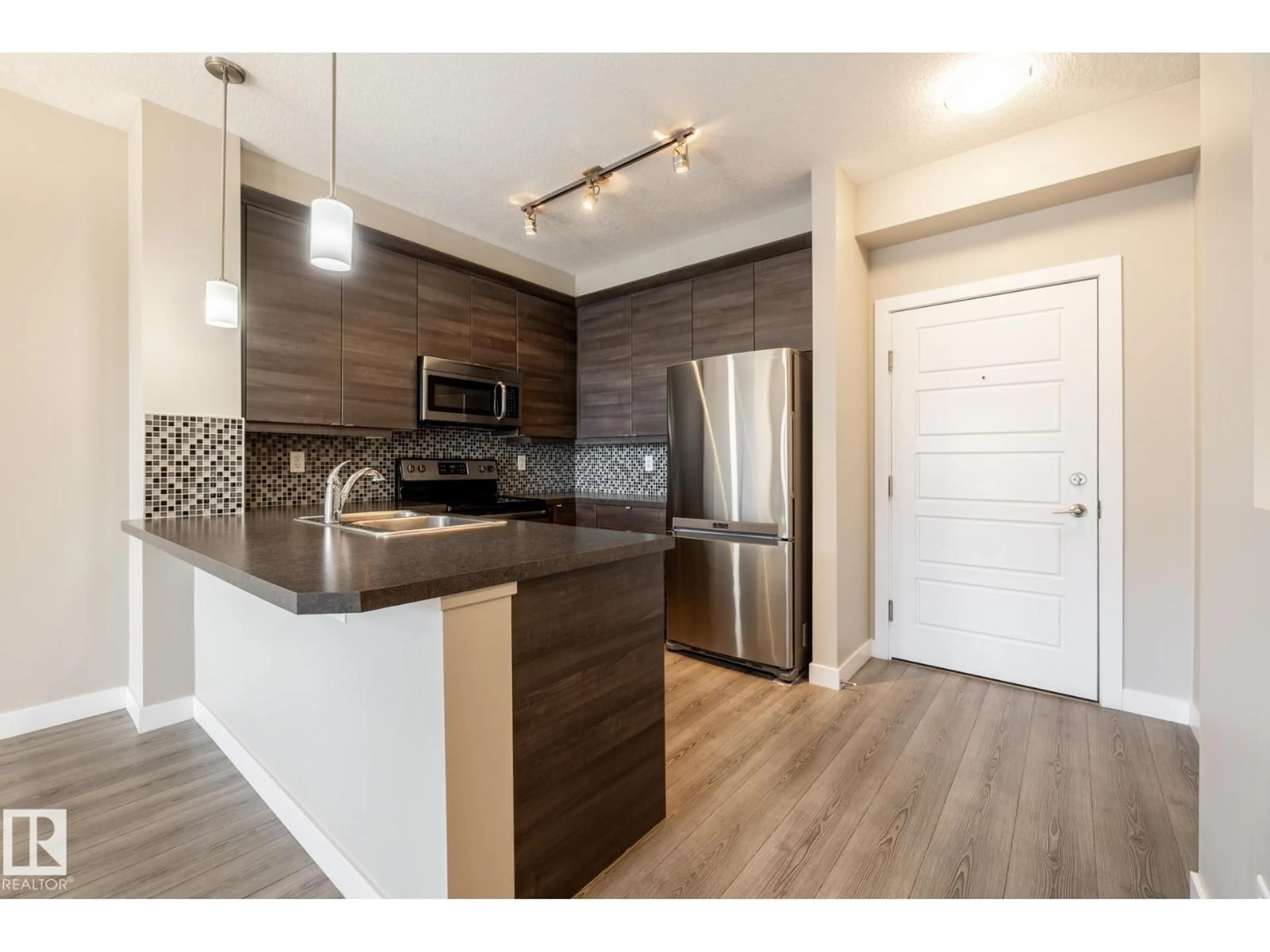 Open concept kitchen, wood/laminate floor for #203 - 2590 ANDERSON WY, Edmonton Alberta T6W0R2