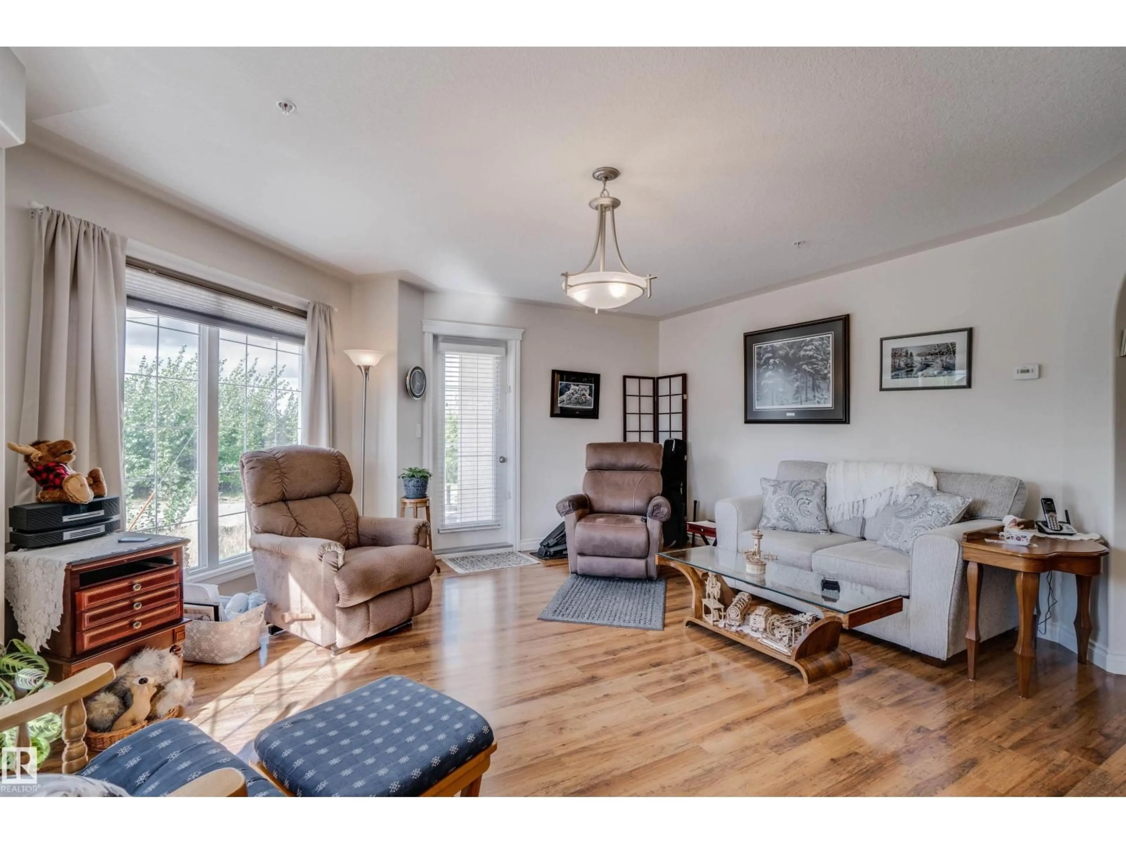 Living room with furniture, wood/laminate floor for #219 - 7801 GOLF COURSE RD, Stony Plain Alberta T7Z0C7