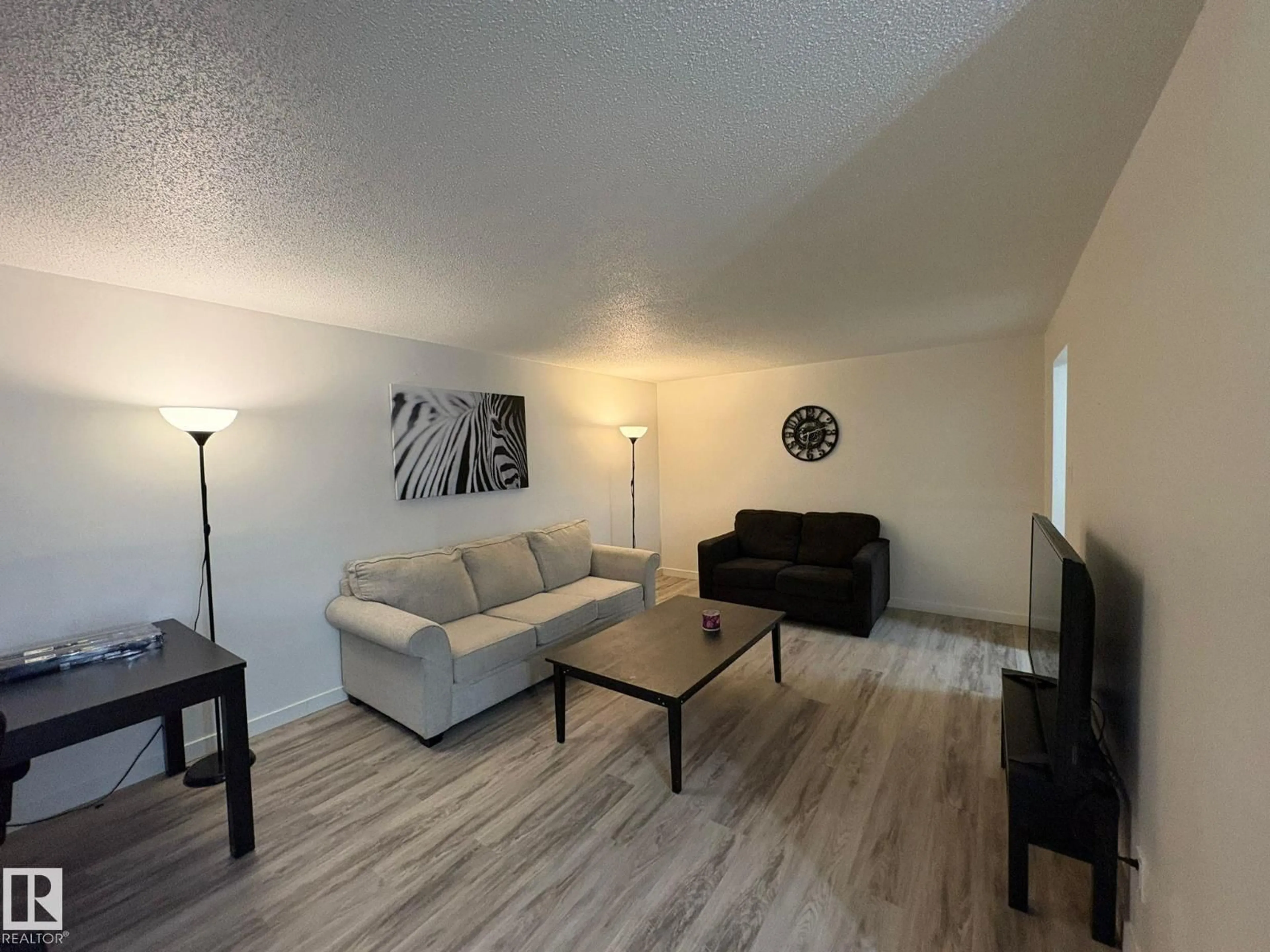 Living room with furniture, wood/laminate floor for #107 - 7204 81 AV, Edmonton Alberta T6B0E2