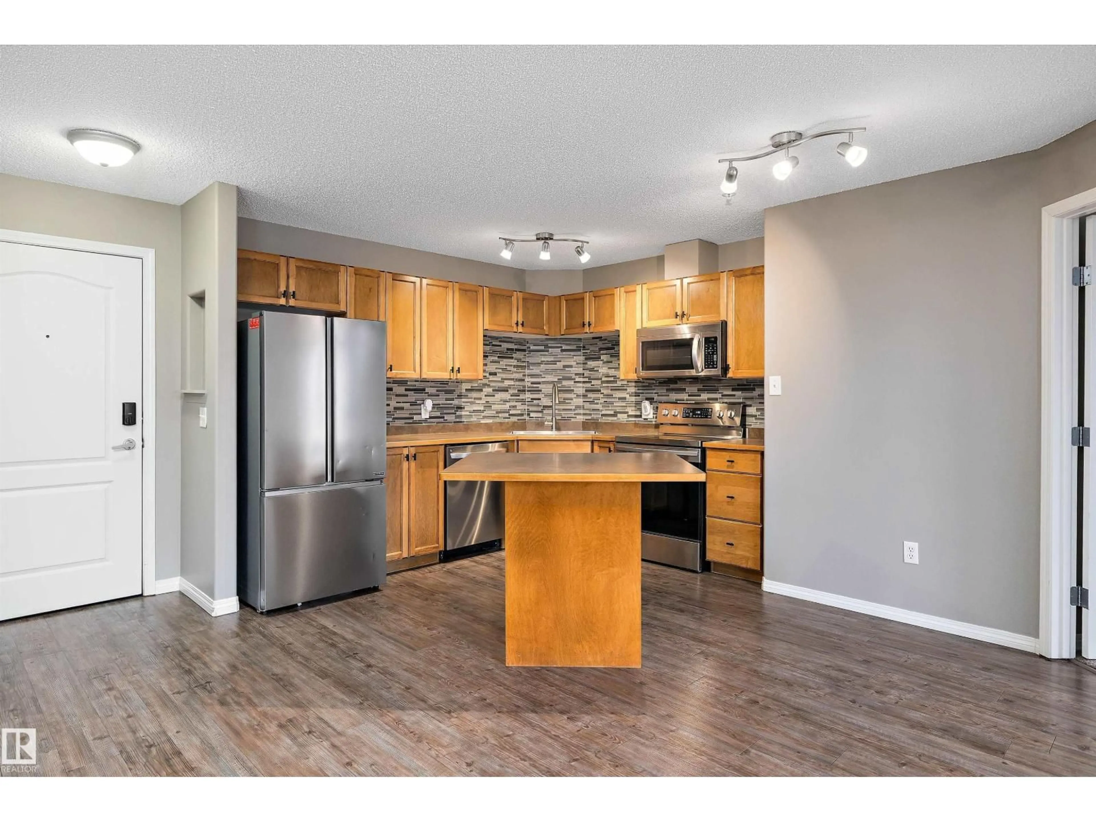 Open concept kitchen, wood/laminate floor for #421 - 5350 199 ST, Edmonton Alberta T6M0A4