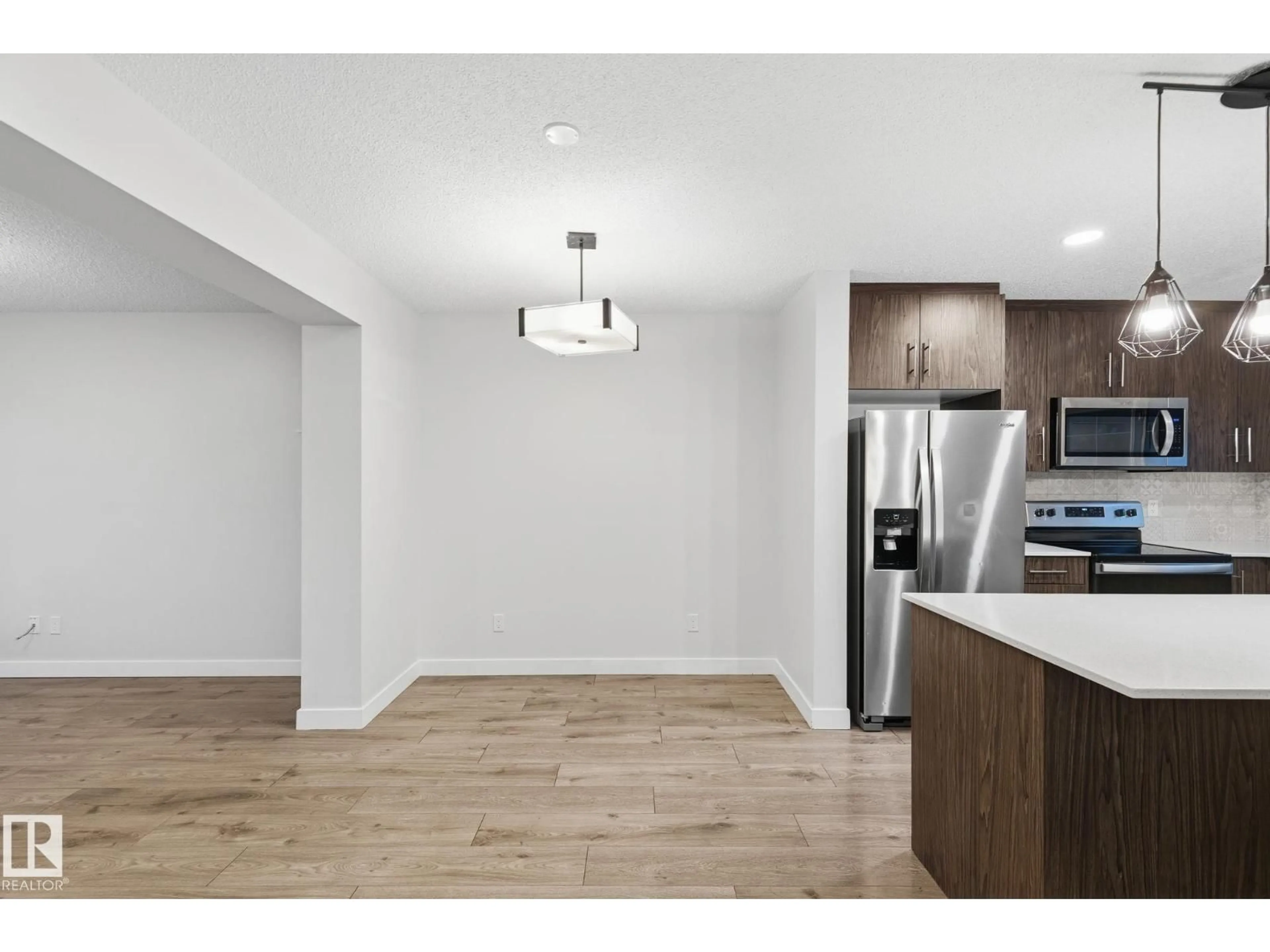 Open concept kitchen, wood/laminate floor for #38 - 3025 151 AV, Edmonton Alberta T5Y3W4