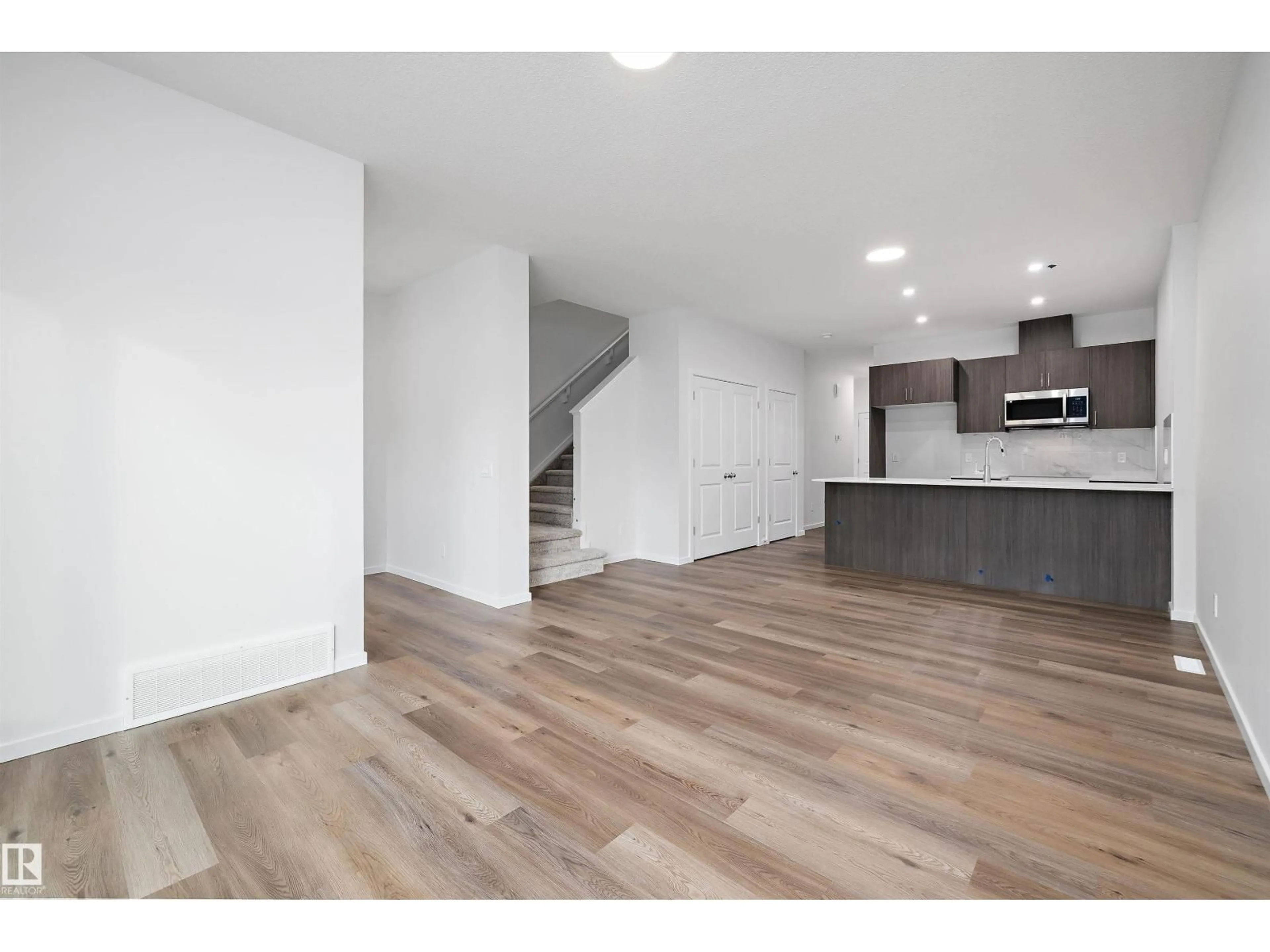 Open concept kitchen, wood/laminate floor for 9107 ELVES LOOP NW, Edmonton Alberta T6M3G2