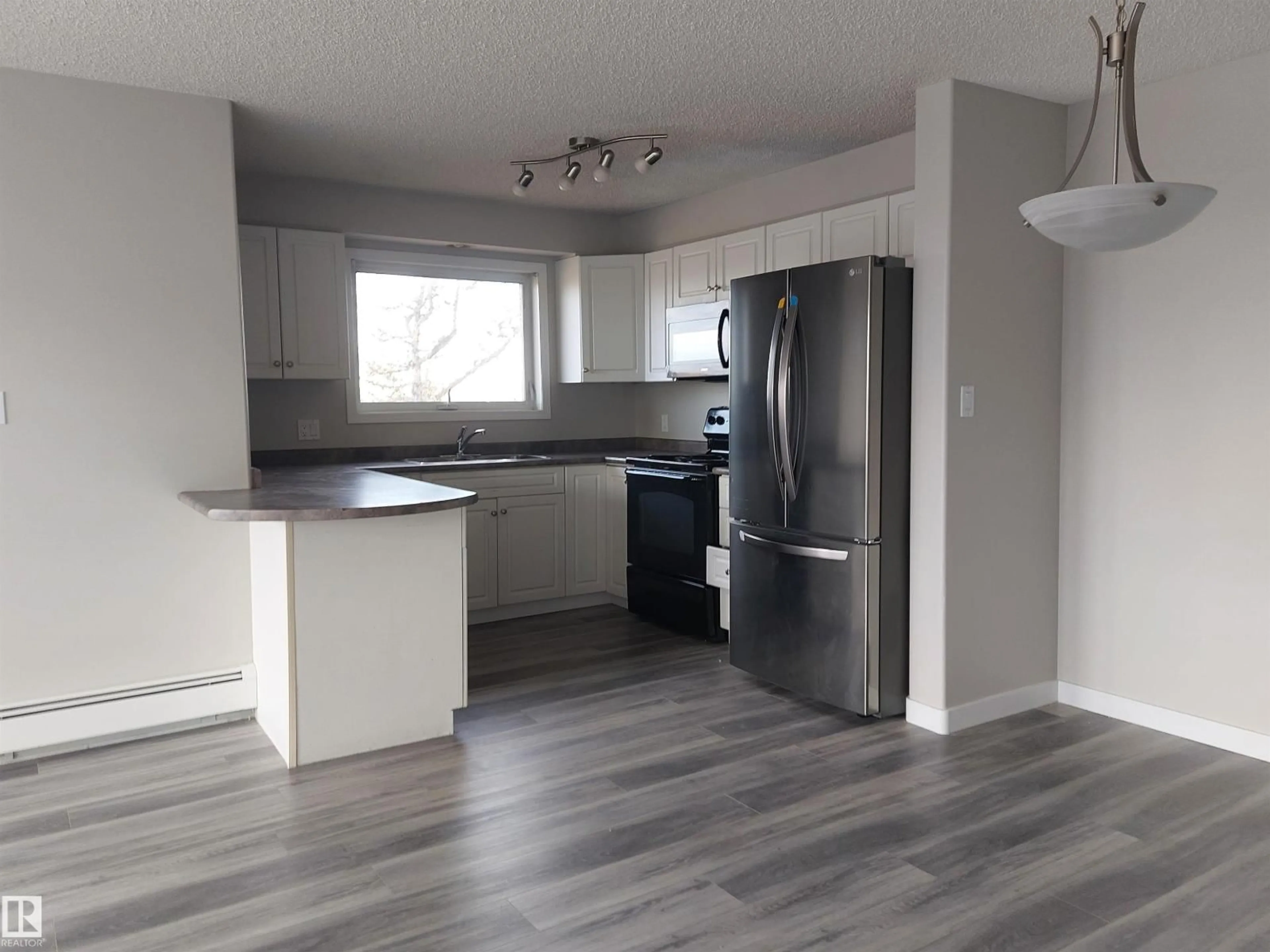 Open concept kitchen, wood/laminate floor for #407 - 13635 34 ST, Edmonton Alberta T5A3W2