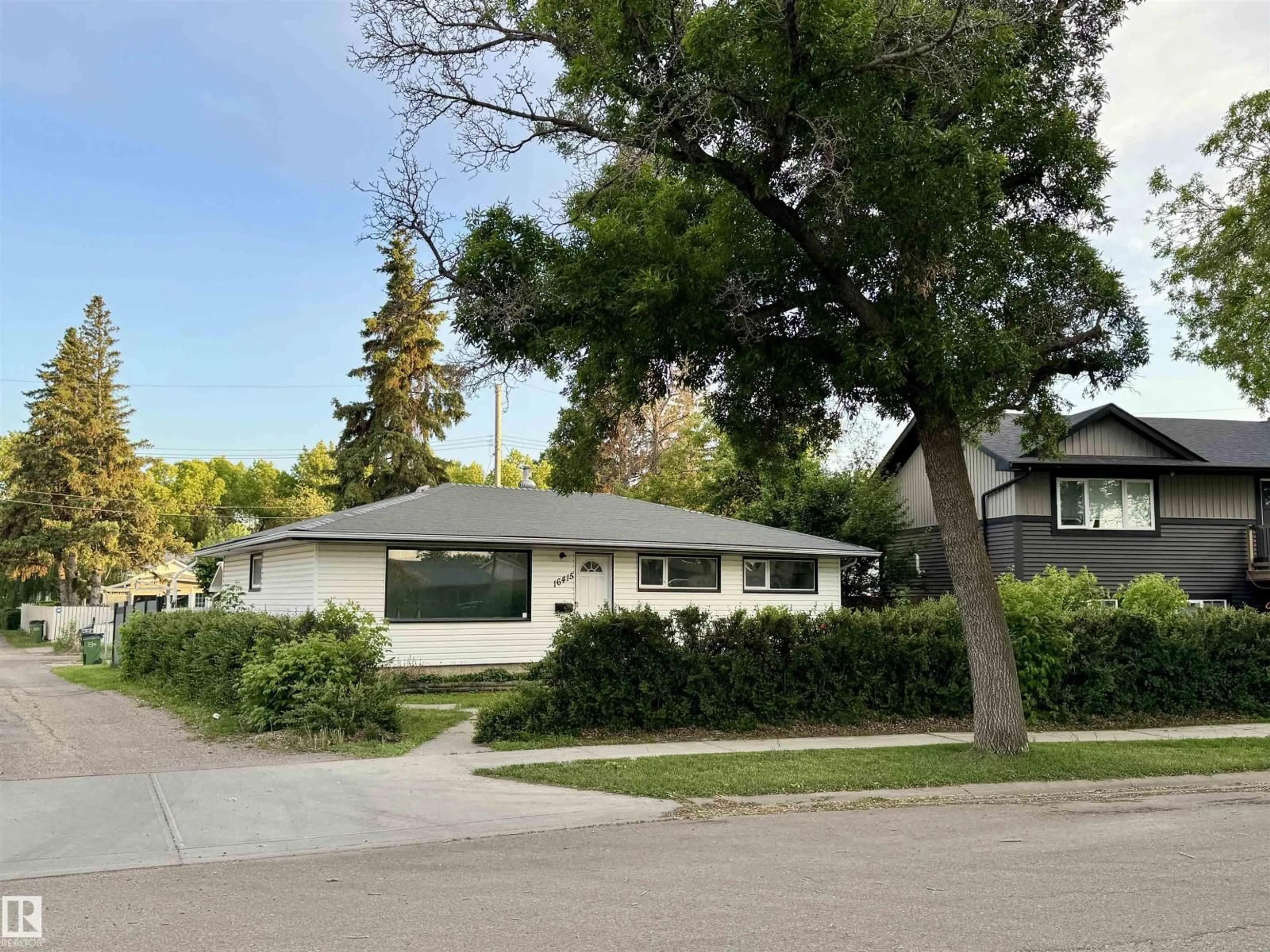 Home with vinyl exterior material, street for NW - 16415 106 AV, Edmonton Alberta T5P0X1