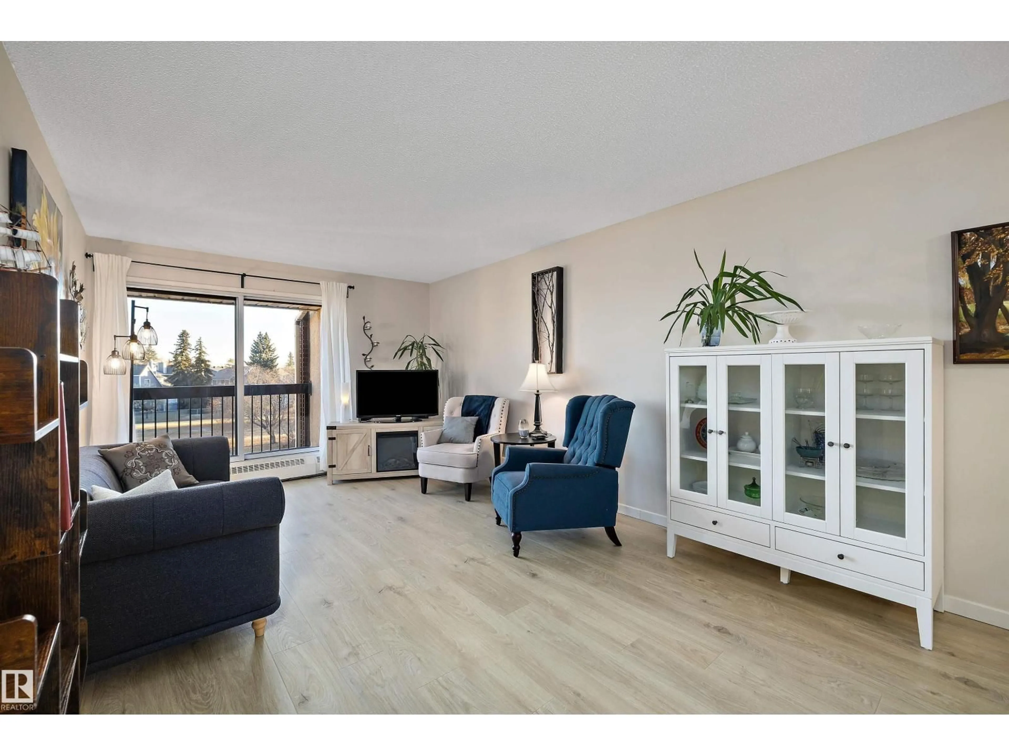 Living room with furniture, wood/laminate floor for 411 10511 19 AV NW, Edmonton Alberta T6J5S8