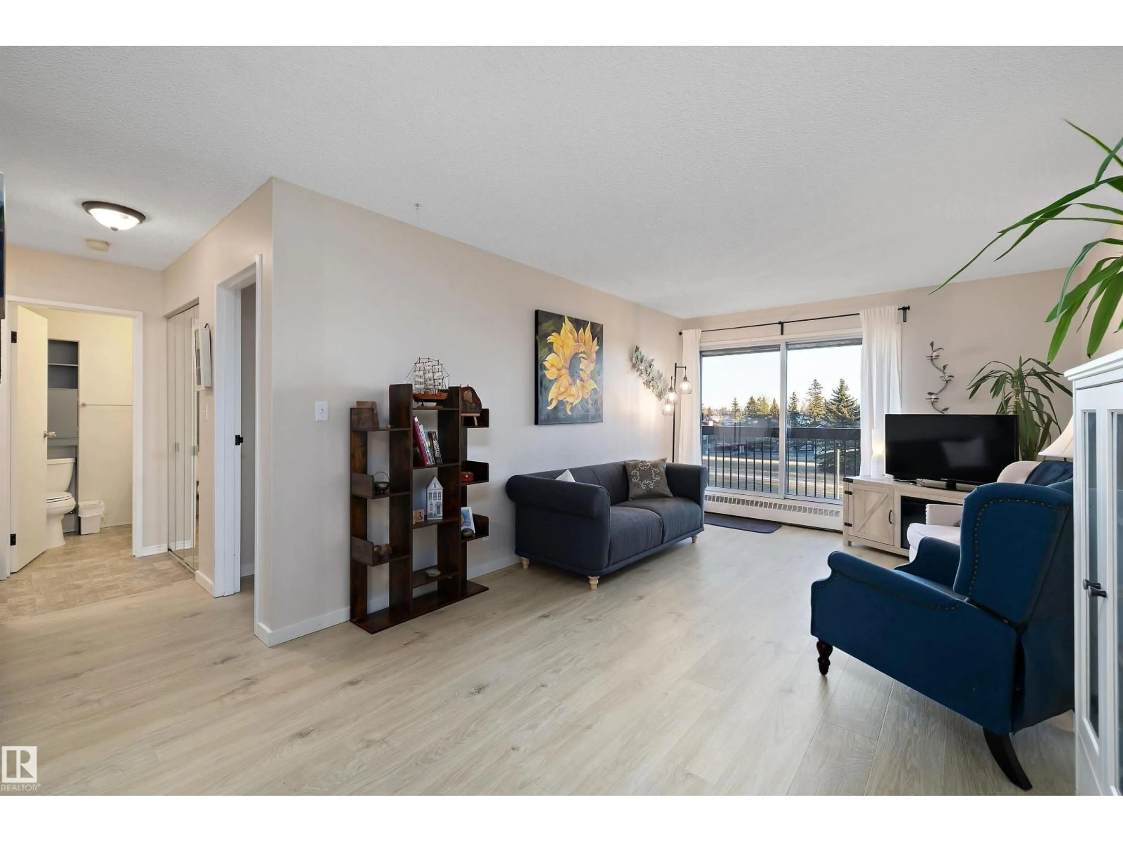 Living room with furniture, wood/laminate floor for 411 10511 19 AV NW, Edmonton Alberta T6J5S8