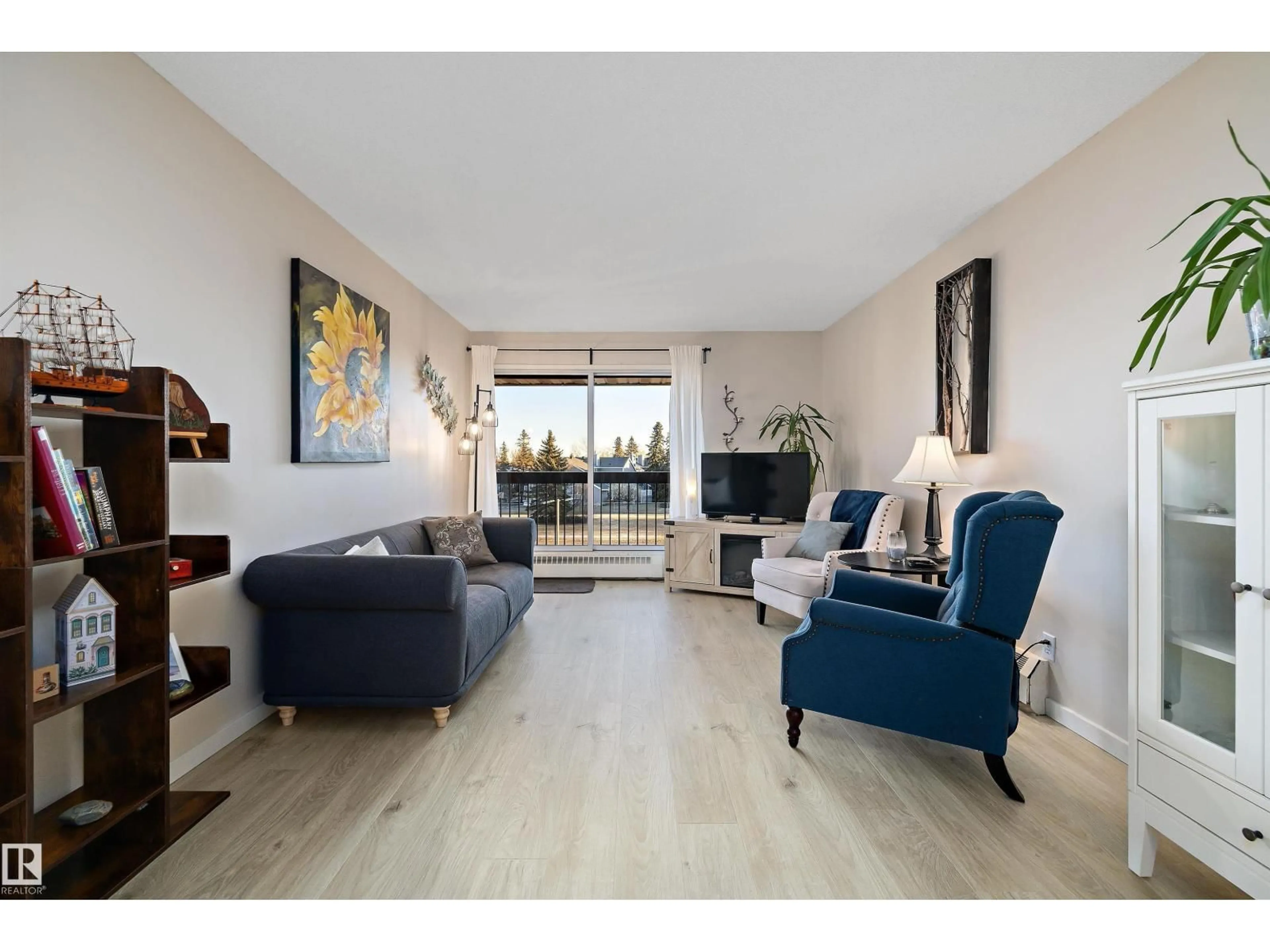 Living room with furniture, wood/laminate floor for 411 10511 19 AV NW, Edmonton Alberta T6J5S8