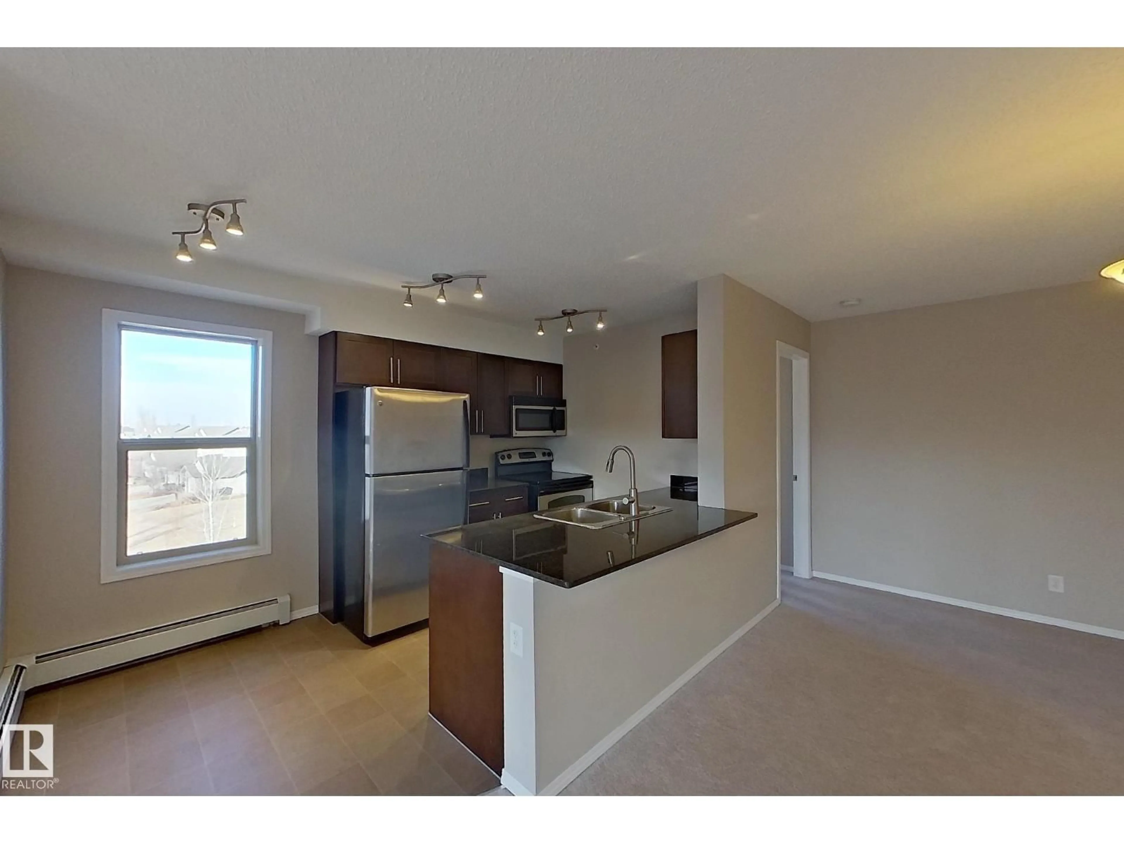 Open concept kitchen, wood/laminate floor for #414 - 11820 22 AV, Edmonton Alberta T6W2A2