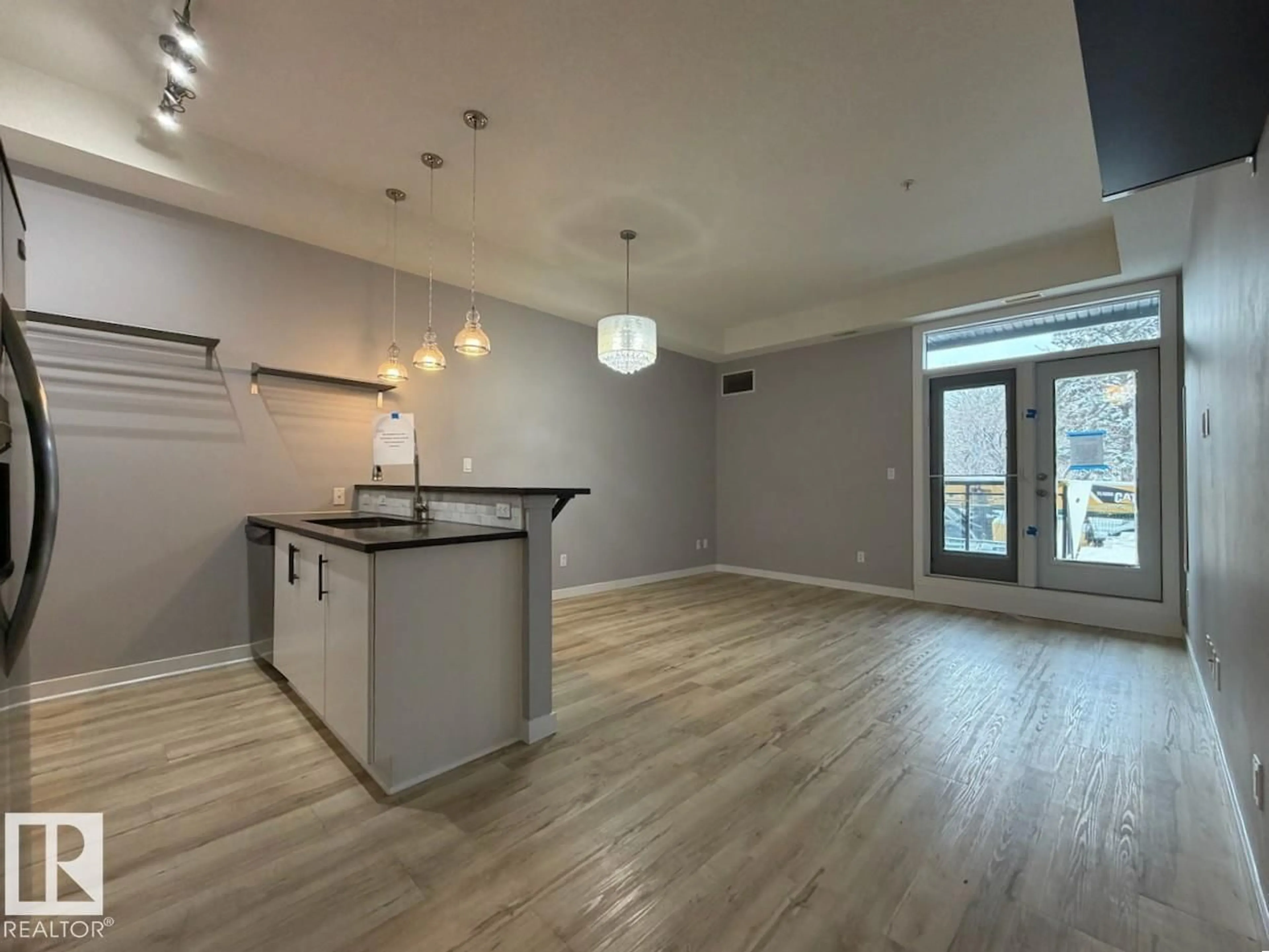 Open concept kitchen, wood/laminate floor for #128 - 10531 117 ST, Edmonton Alberta T5H0A8