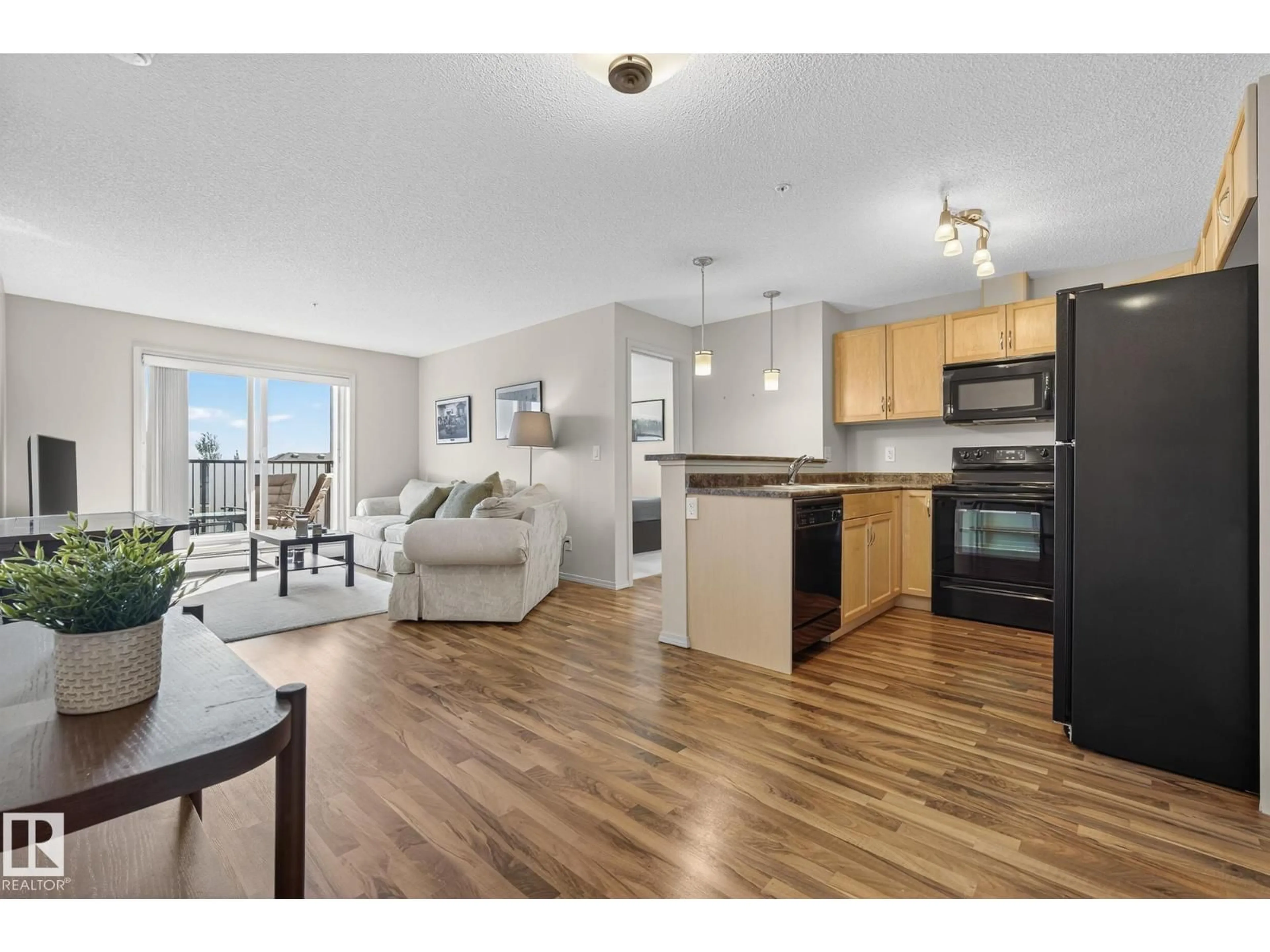Open concept kitchen, wood/laminate floor for #310 - 6070 SCHONSEE WY, Edmonton Alberta T5Z0G8