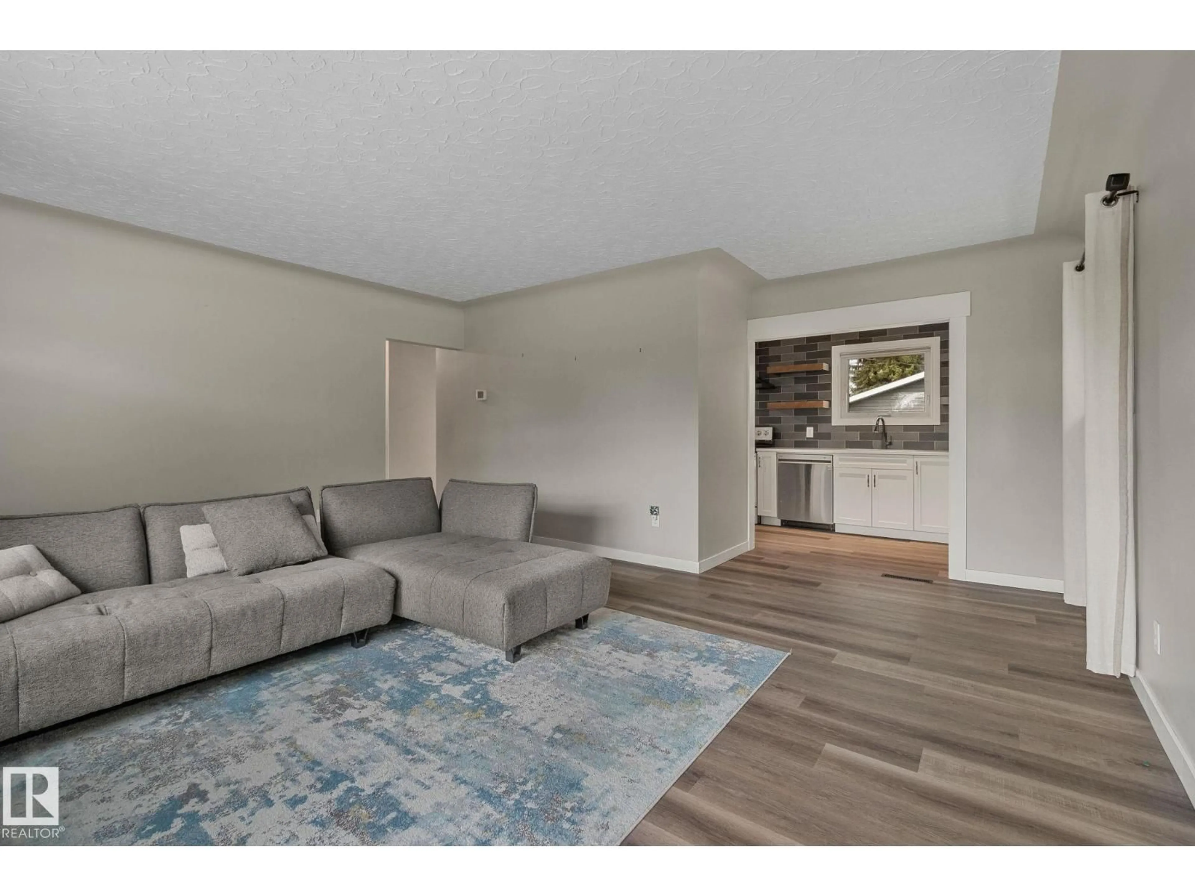 Living room with furniture, wood/laminate floor for NW - 10324 50 ST, Edmonton Alberta T6A2C4