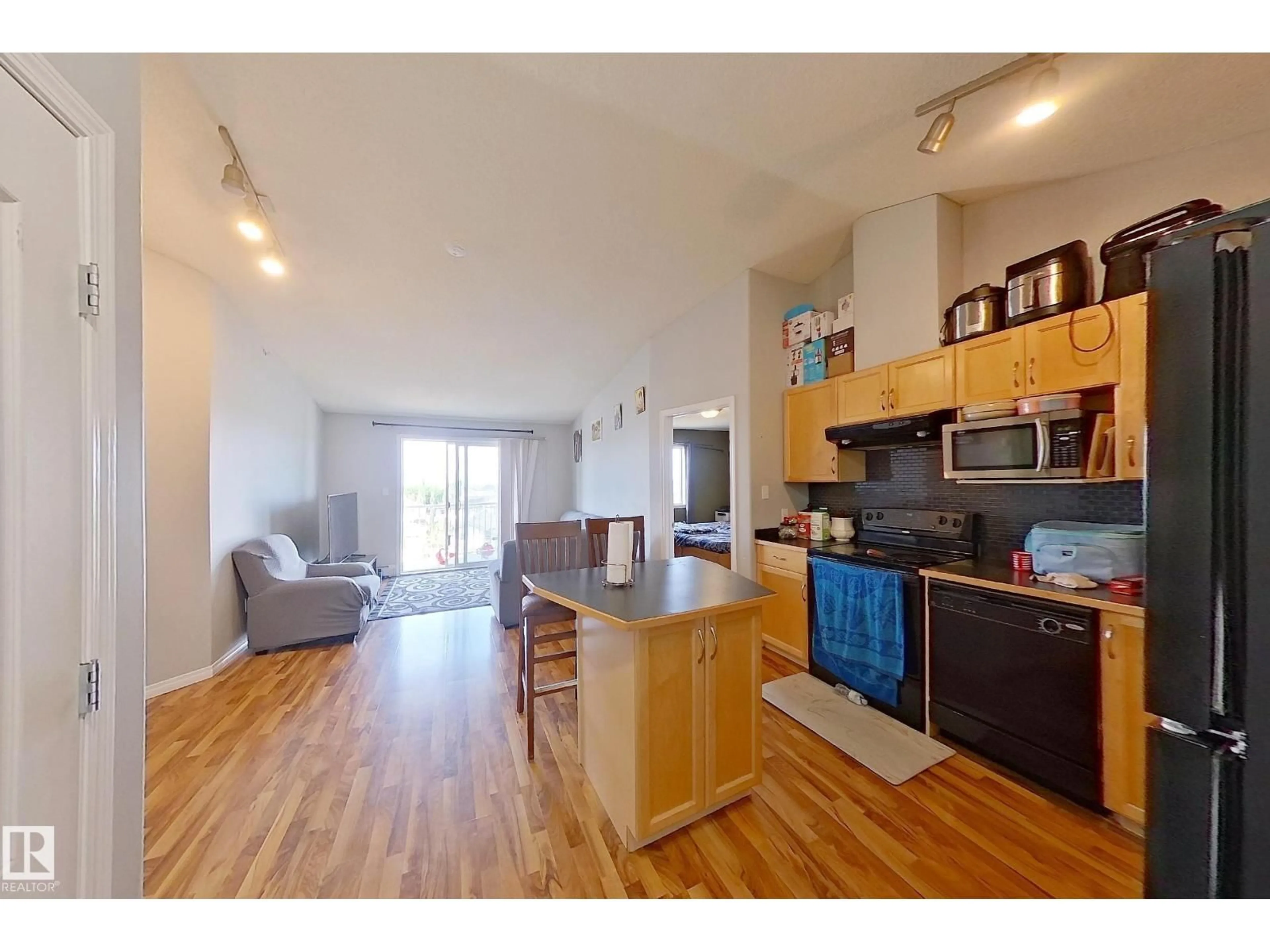 Open concept kitchen, wood/laminate floor for #418 - 3425 19 ST, Edmonton Alberta T6T2B5