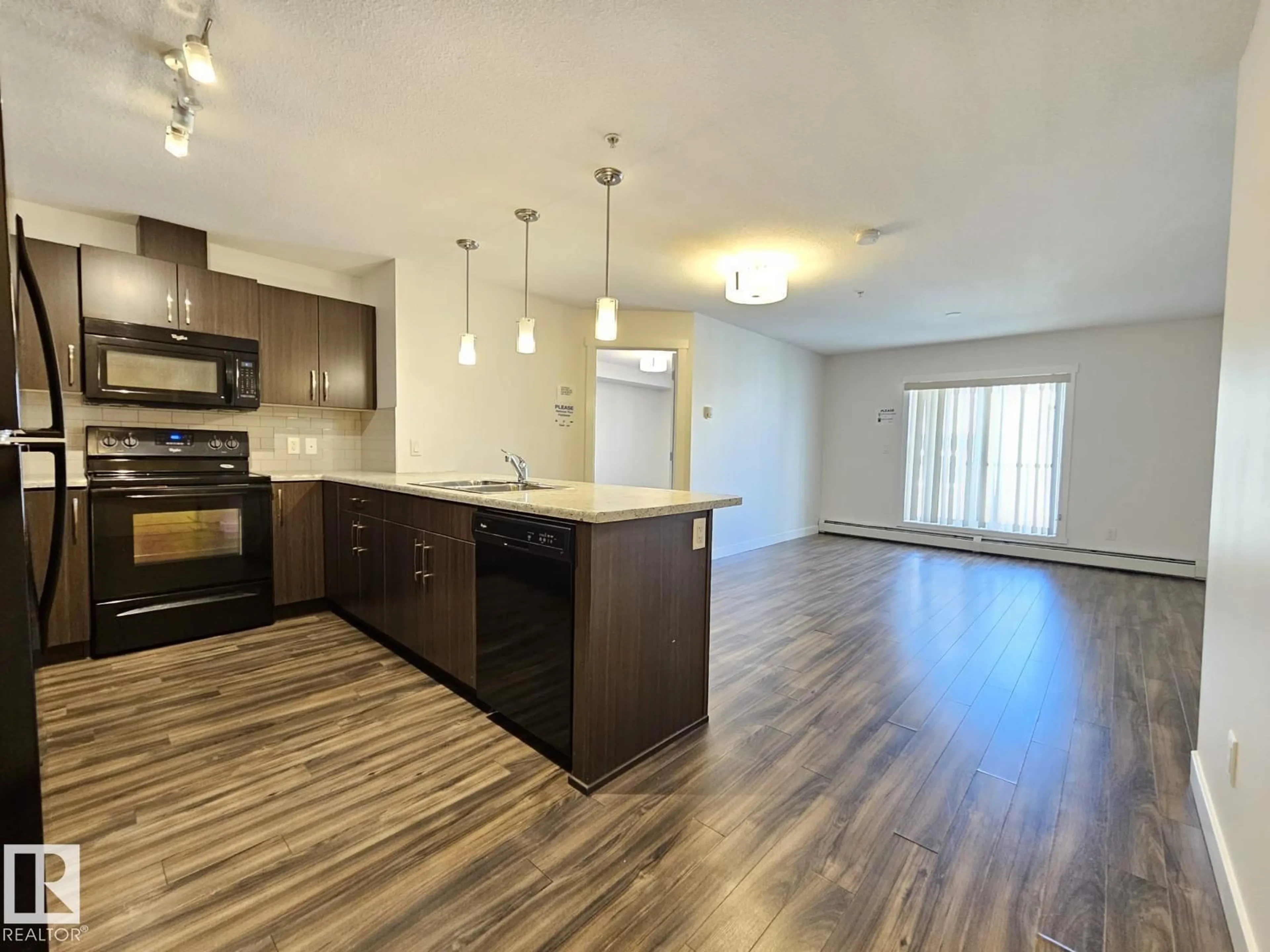 Open concept kitchen, wood/laminate floor for 205 - 3670 139 AV, Edmonton Alberta T5Y3N5